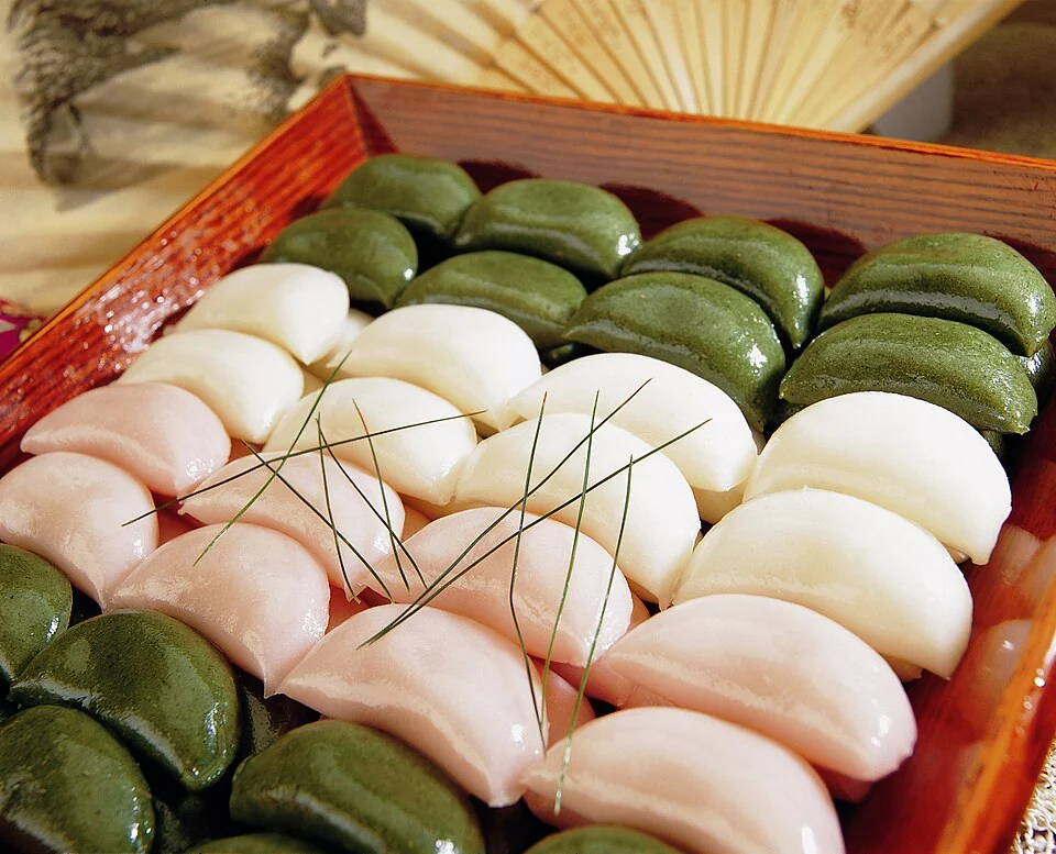 White, pink and green songpyeon rice cakes arranged on a tray.