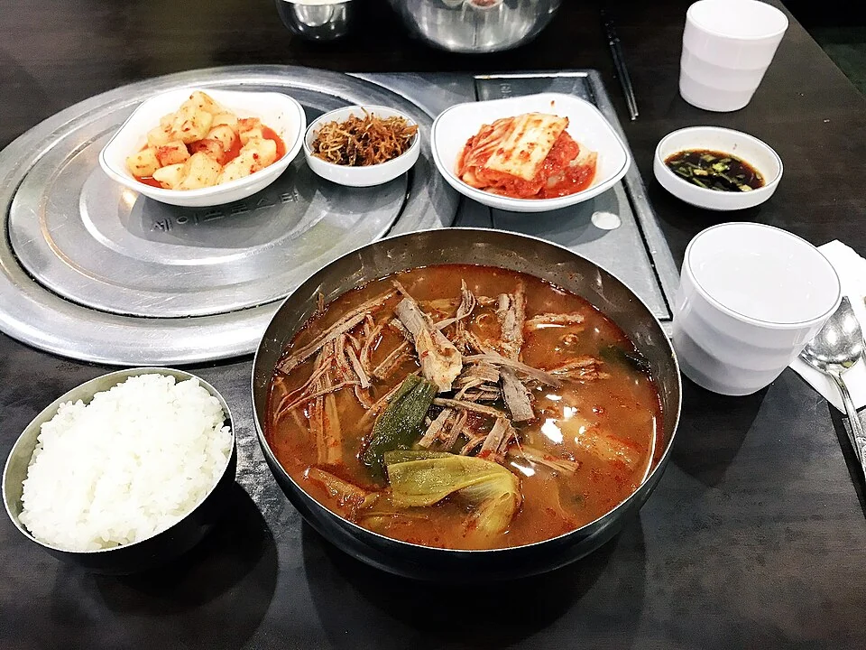 Spicy beef soup served with rice and Korean side dishes.
