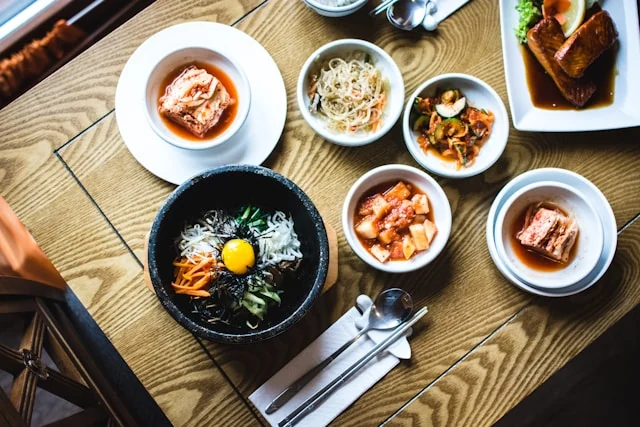 A Korean meal with a central bowl and several small side dishes.