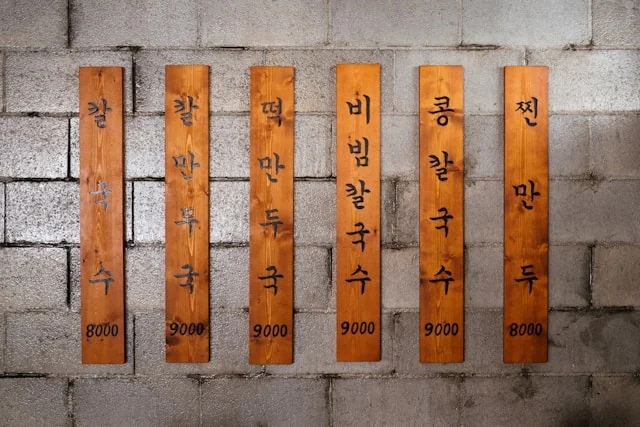 Wooden Korean restaurant menu boards displaying dishes and prices.