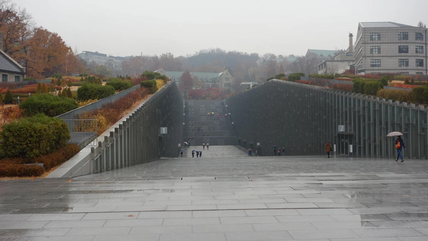 Descending walkway between the glass façades of the Ewha Campus Complex in Seoul