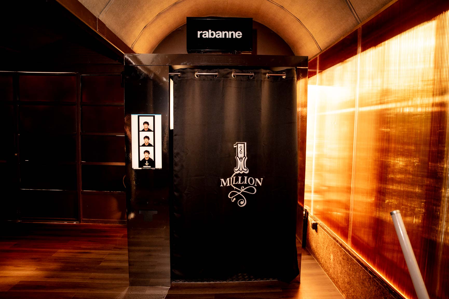 Rabanne One Million branded photobooth with black curtain and photo strip, translucent golden wall, One Million Tour pop-up in Madrid produced by ESMA Events