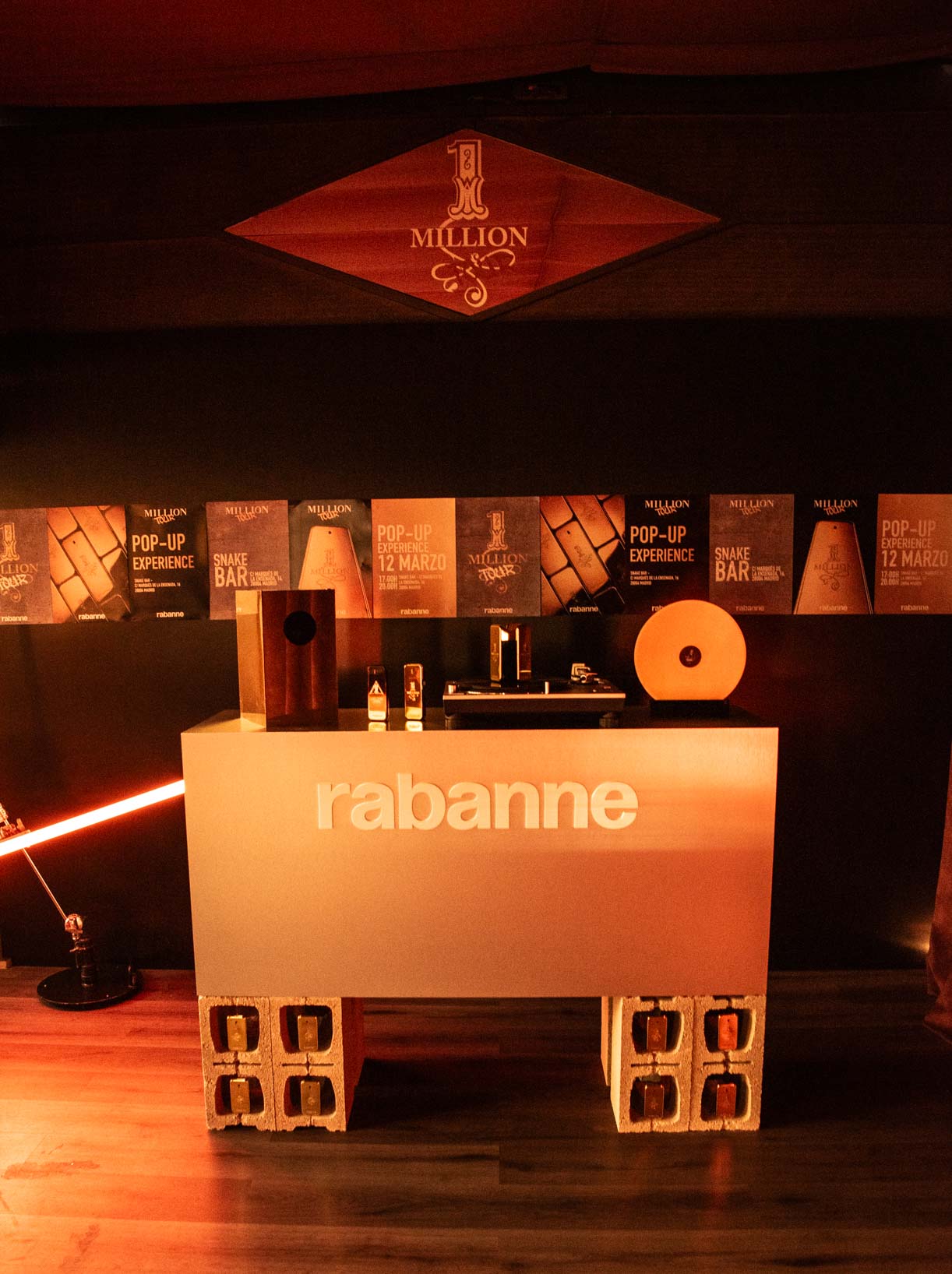 Illuminated white Rabanne bar with brand logo, pop-up experience posters and One Million diamond projected in the Madrid event space