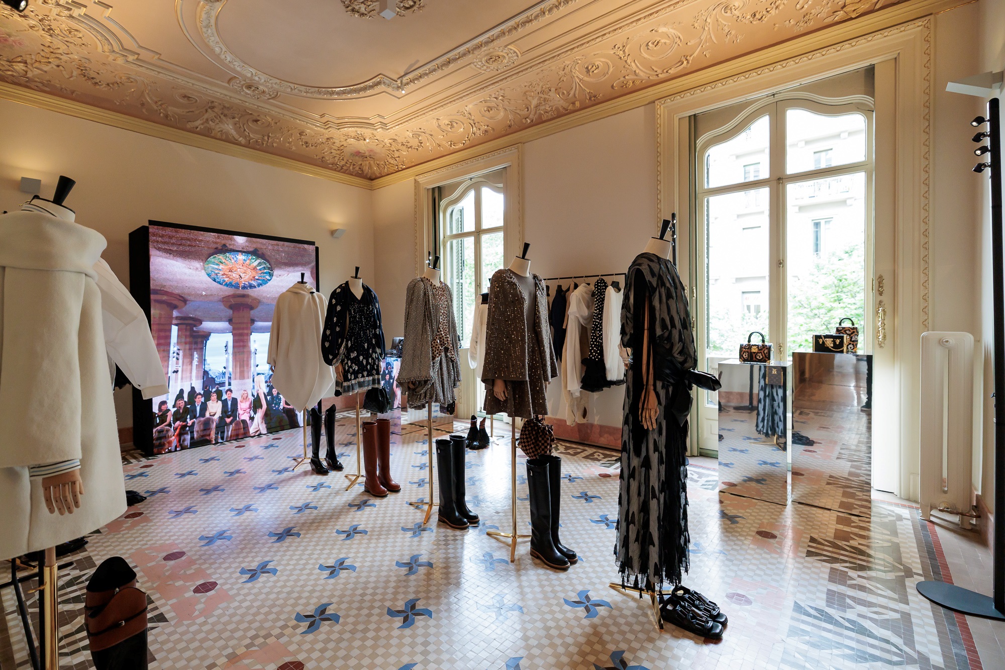 Louis Vuitton Cruise 2025 collection display with mannequins and video screen in ornate hall, ESMA Events production Barcelona