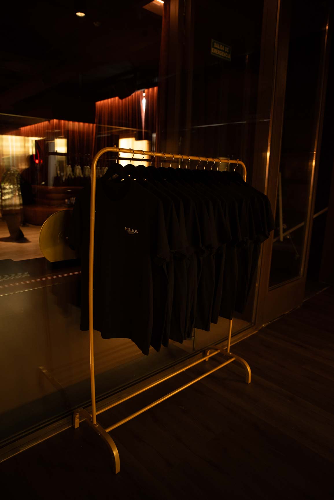 Perchero dorado con prendas negras de Rabanne en el interior del pop-up One Million Tour Madrid