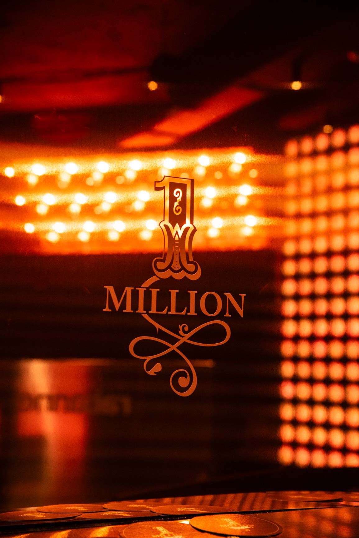 Panel de marca Rabanne One Million con iluminación LED ámbar y pantallas de matriz de puntos, interior del pop-up One Million Tour Madrid