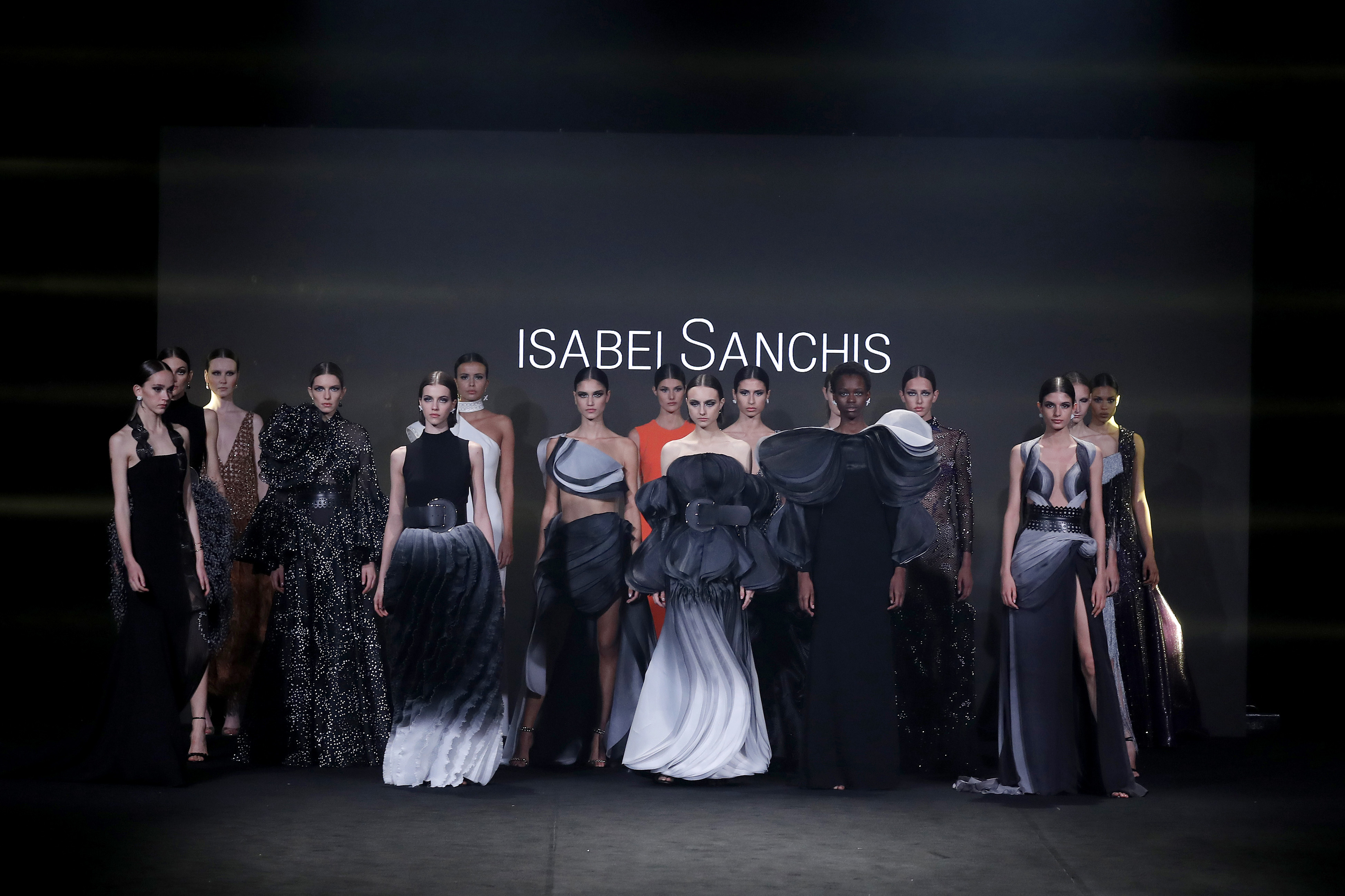 Final del desfile con modelos con vestidos negros y grises de volumen ante el nombre Isabel Sanchis, Mercedes-Benz Fashion Week Madrid FW 2021 producida por ESMA Events