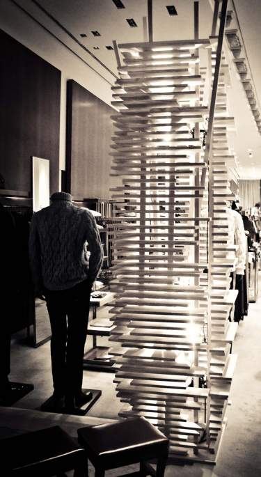 Escultura de listones blancos apilados junto a un maniquí con jersey de punto en una tienda, en blanco y negro, evento de Hermès producido por ESMA Events