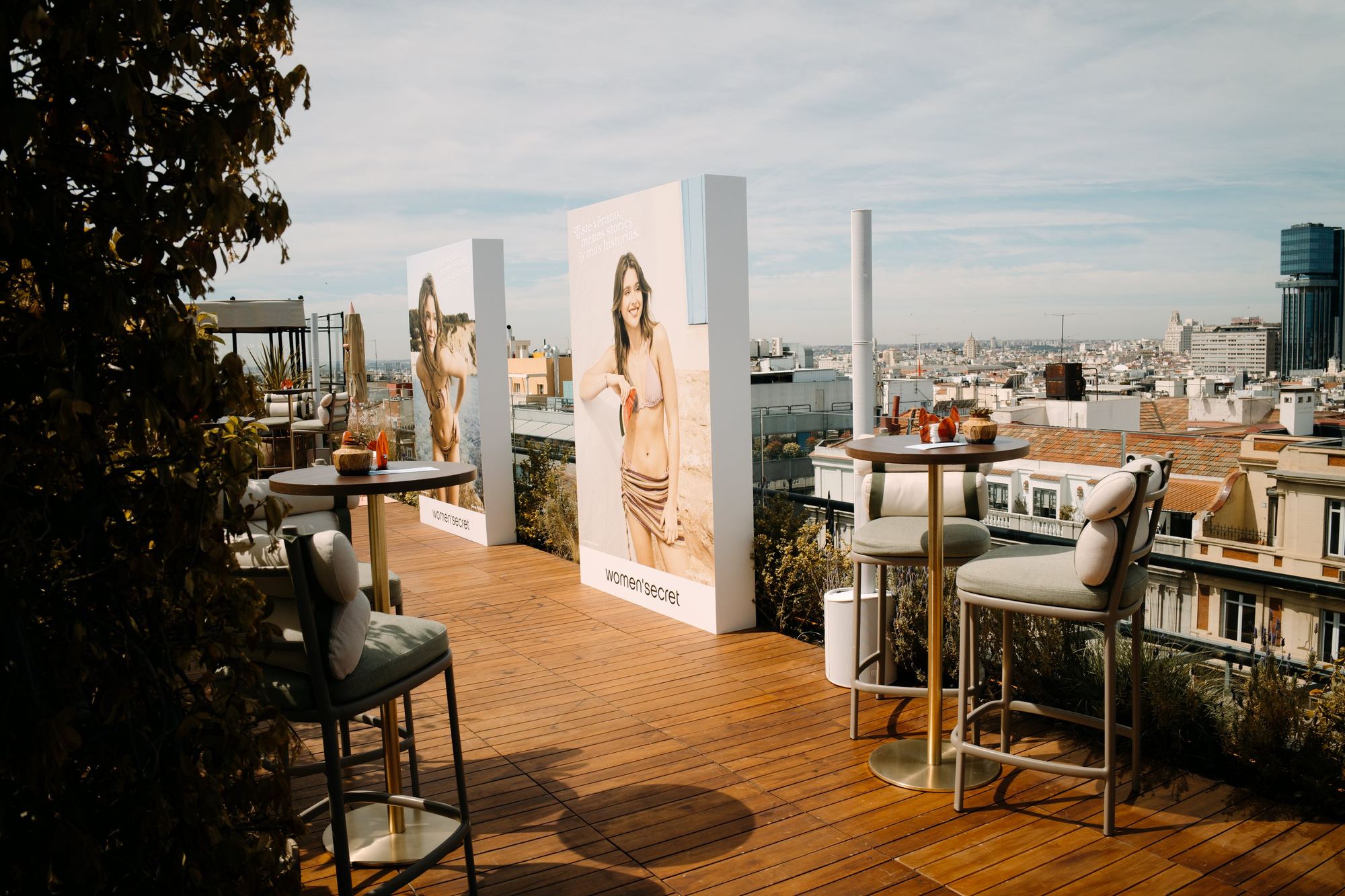 Terraza con mesas altas y paneles con modelos de Women'secret y vistas a la ciudad, evento Women'secret Servir Verano producido por ESMA Events