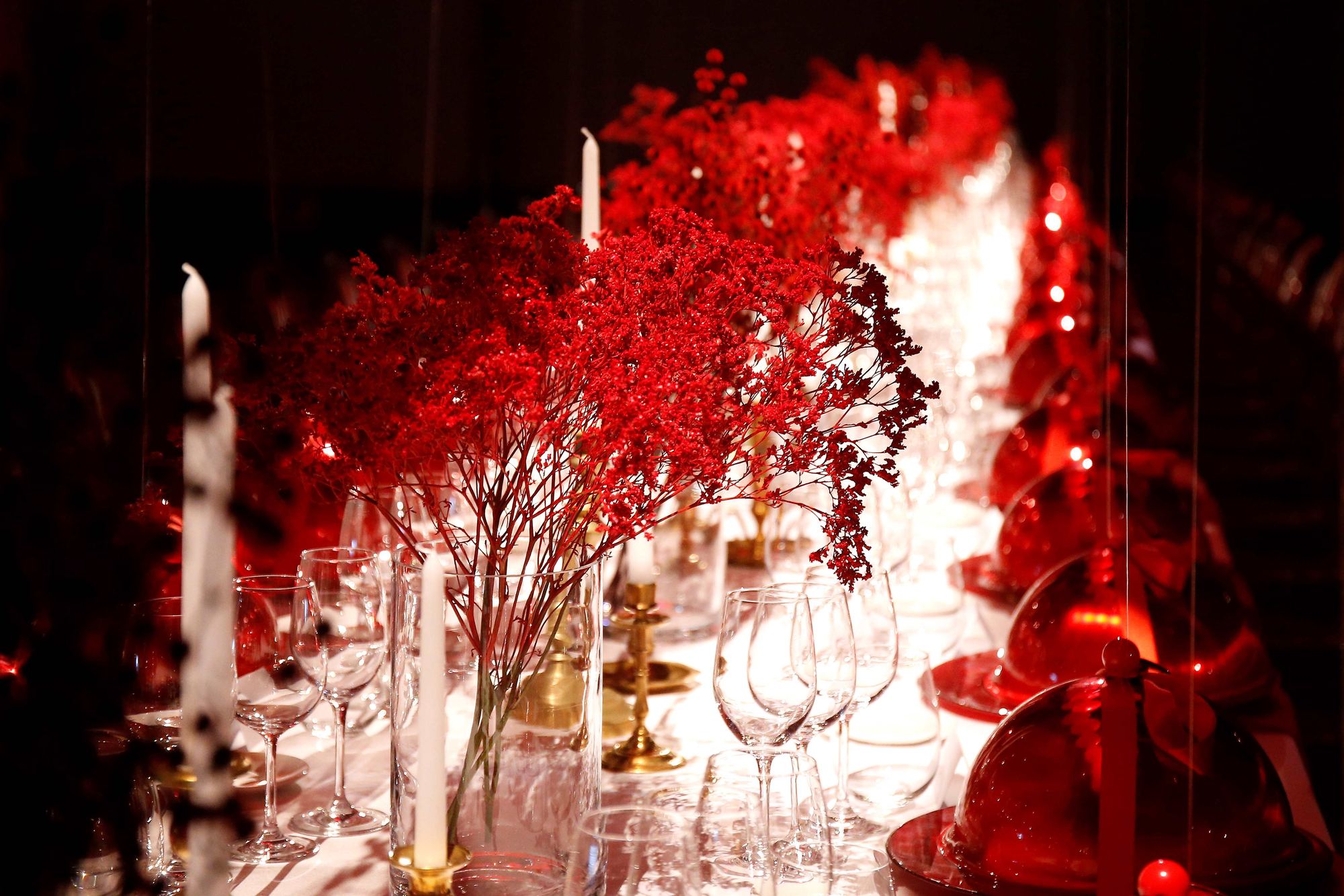 Mesa de cena de gala con ramos rojos, velas y copas de cristal, ambientación del Louboutin Gala Dinner producido por ESMA Events