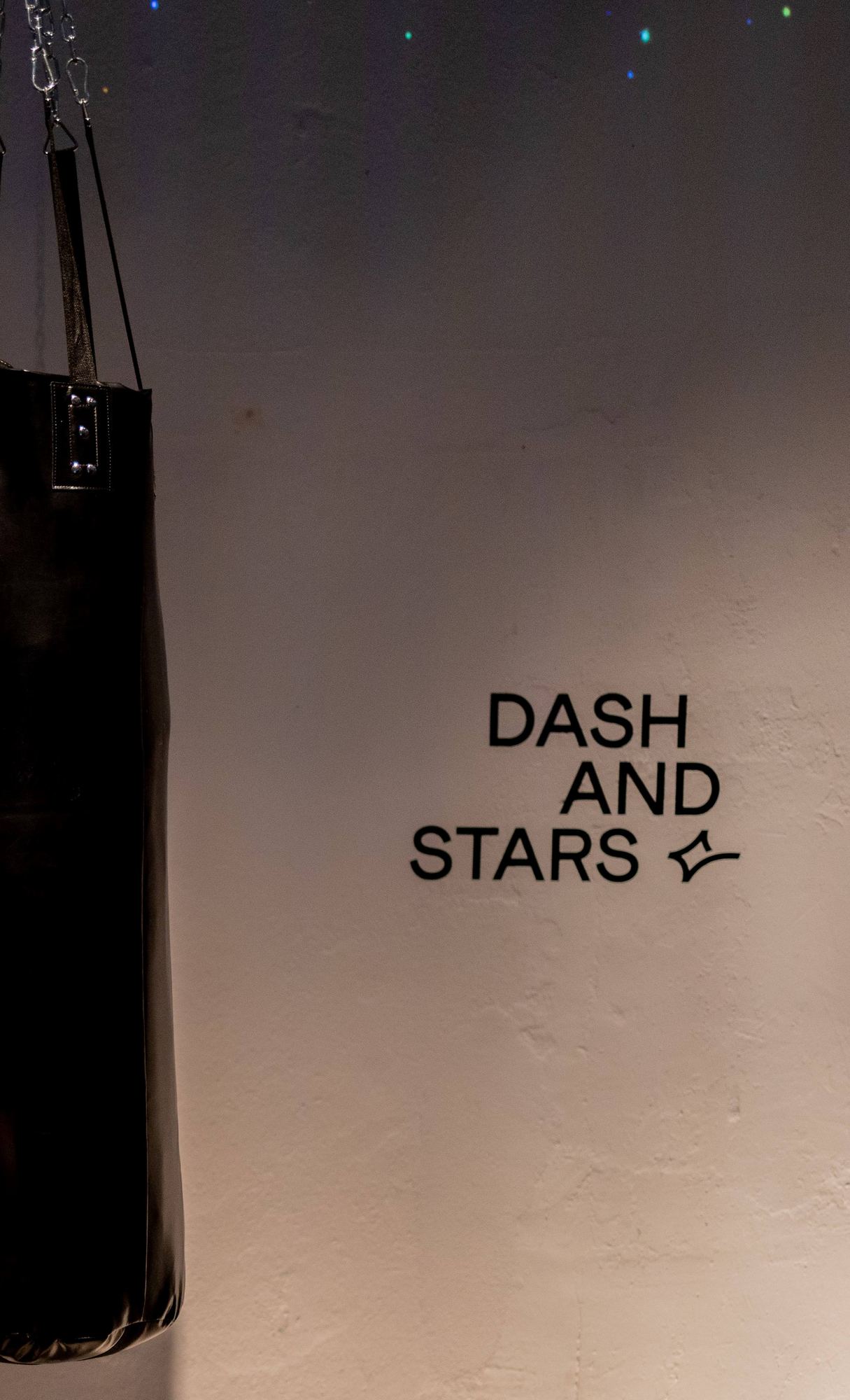 Saco de boxeo colgado junto al logotipo de Dash&Stars sobre una pared clara, lanzamiento de Dash&Stars producido por ESMA Events