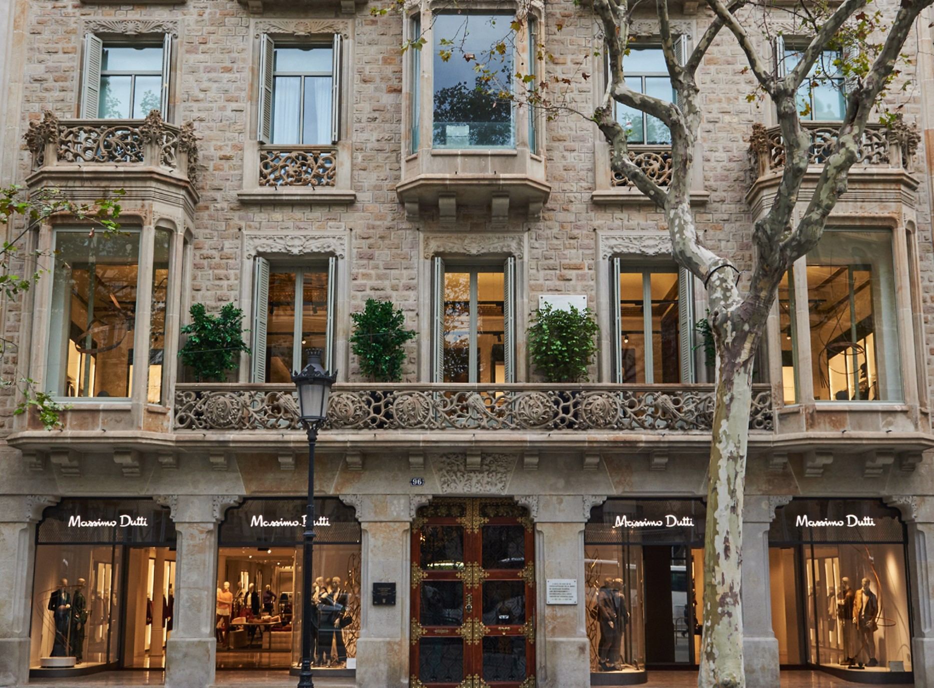 Fachada histórica de piedra con balcones y los escaparates iluminados de la tienda, evento de la Massimo Dutti Flagship Store producido por ESMA Events