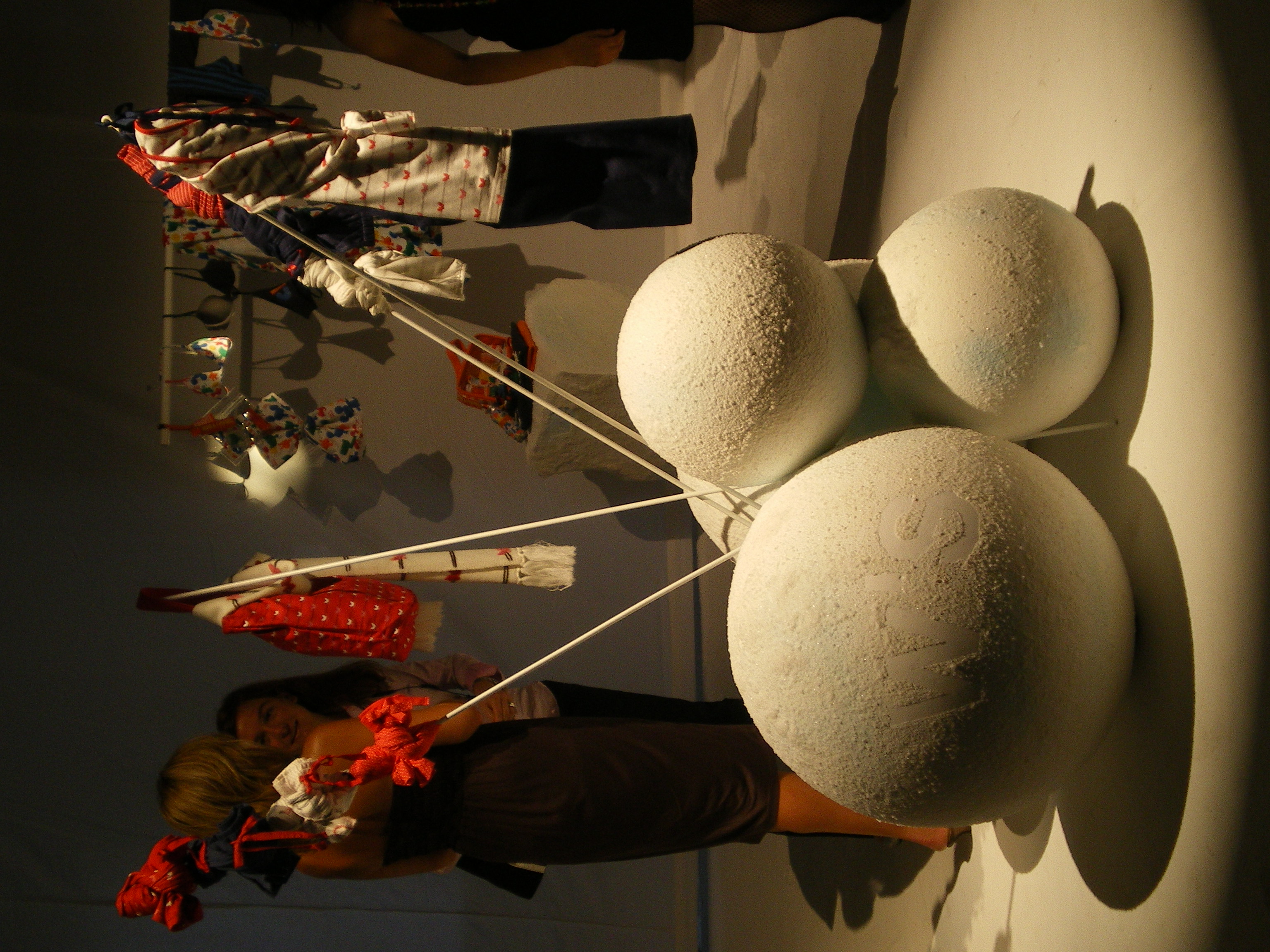 White spheres with rods holding red garments and bows, with attendees in the background, Women'secret September 2007 collection launch produced by ESMA Events