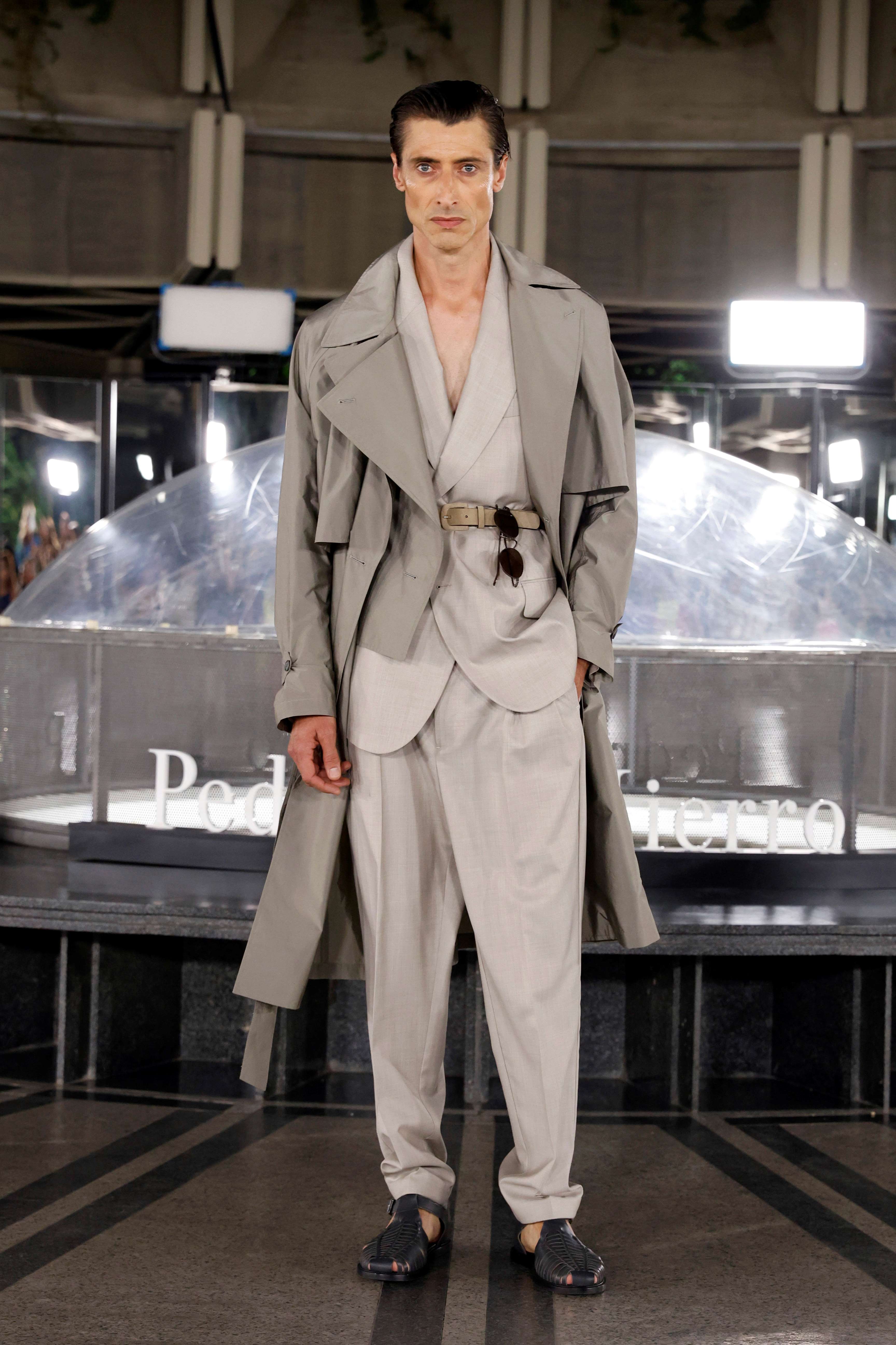 Modelo masculino con gabardina larga, chaleco y pantalón claro ante la cúpula, desfile Pedro del Hierro SS25 producido por ESMA Events