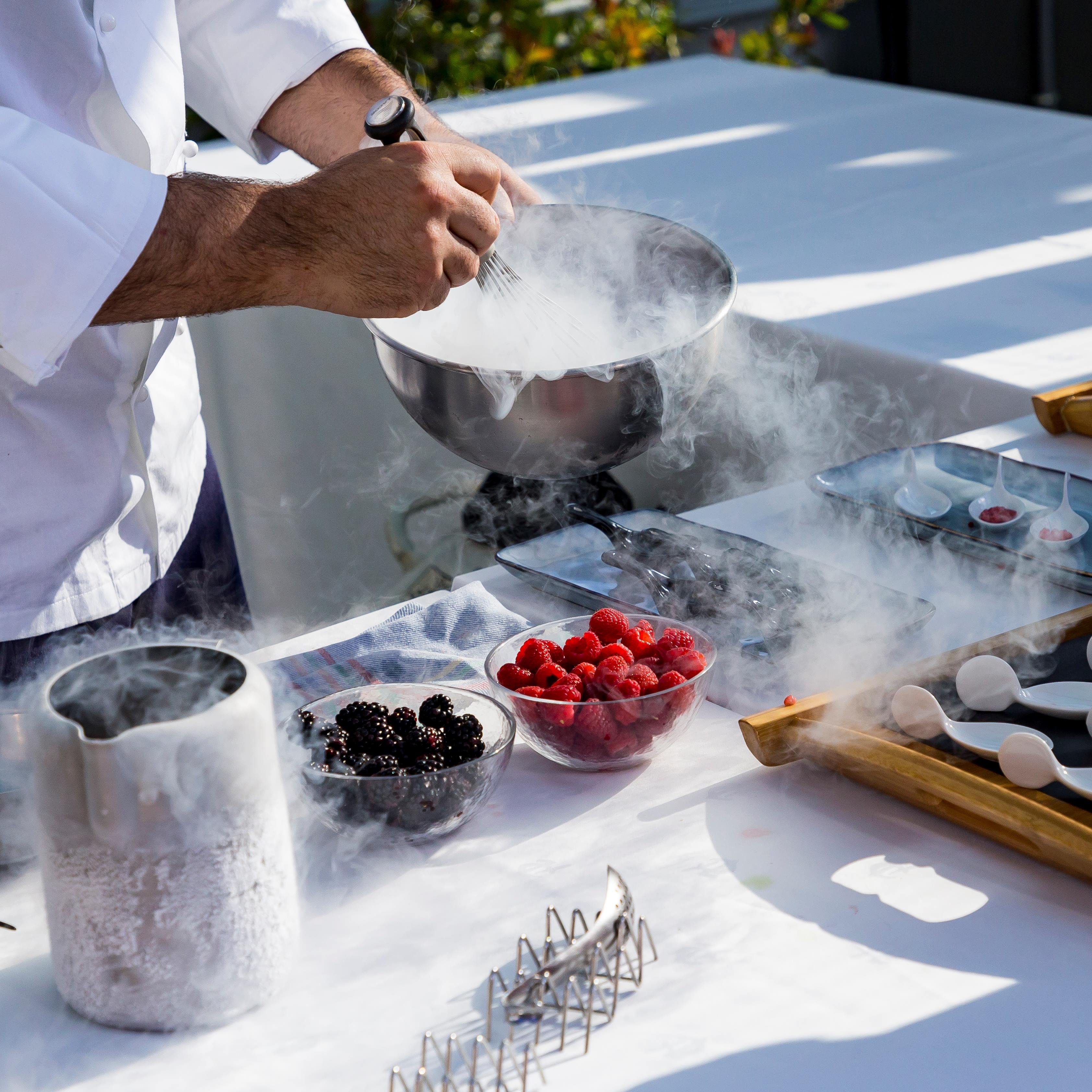 Chef preparando postres con nitrógeno líquido junto a un bol de frutos rojos, evento Women'secret Nos gusta el verano producido por ESMA Events