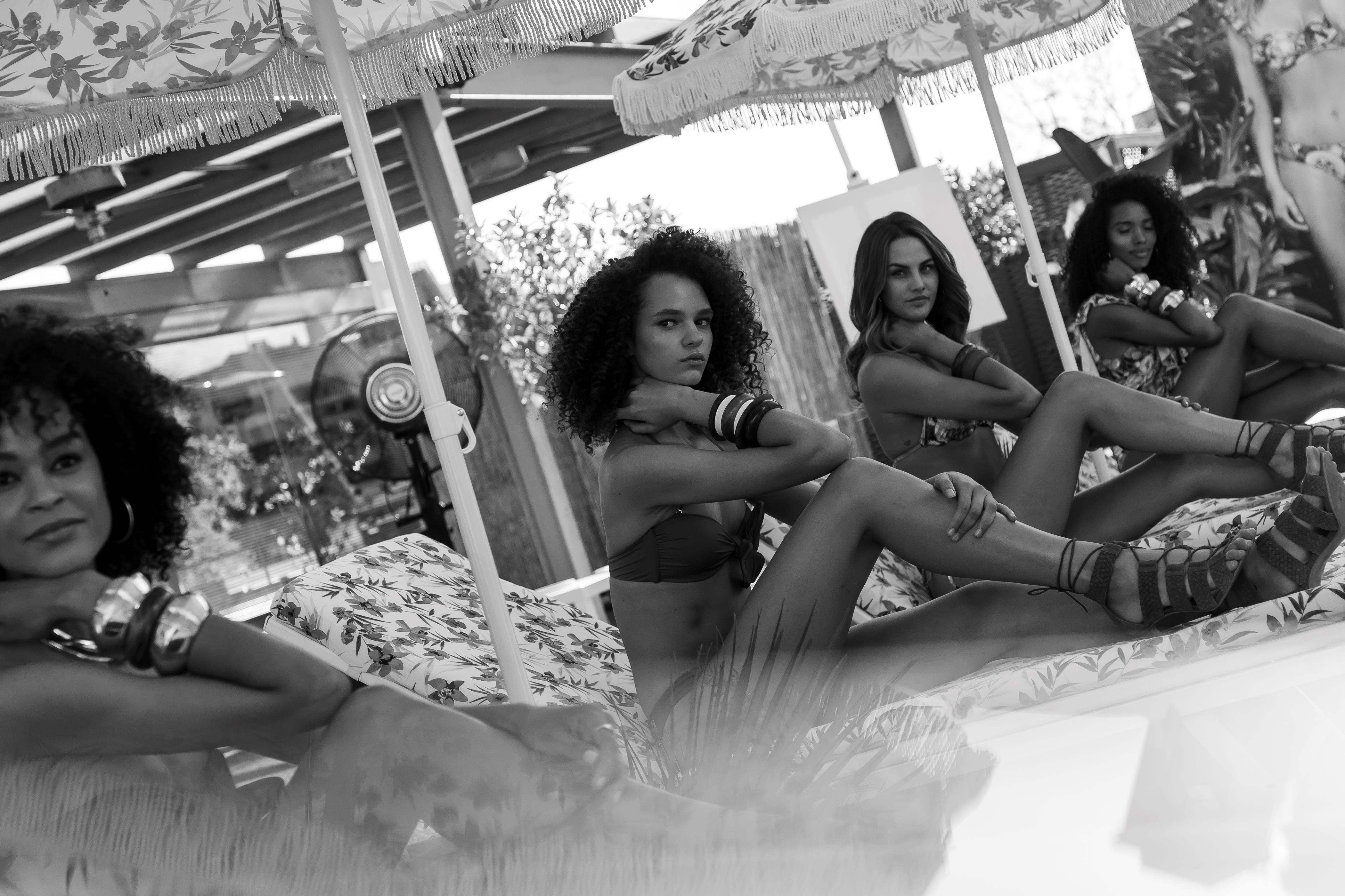 Modelos sentadas bajo sombrillas de flecos posando en blanco y negro, evento Women'secret Nos gusta el verano producido por ESMA Events