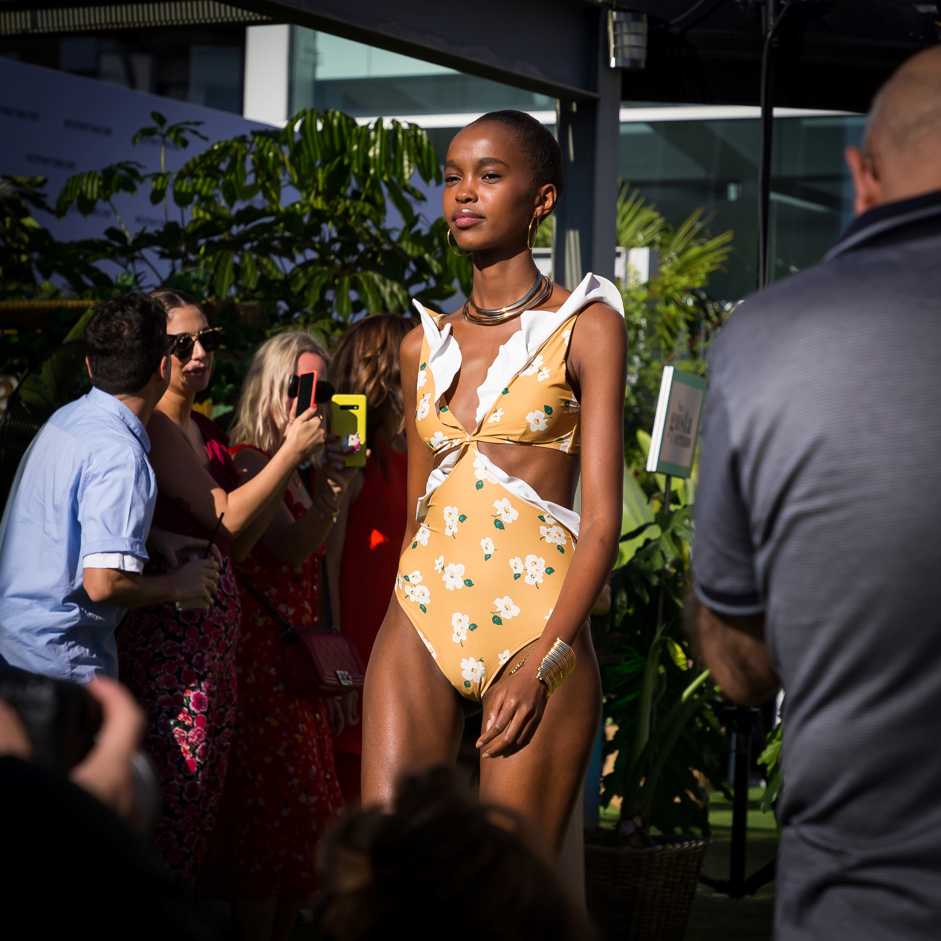 Modelo con bañador amarillo de flores y volantes ante fotógrafos e invitados, evento Women'secret Nos gusta el verano producido por ESMA Events