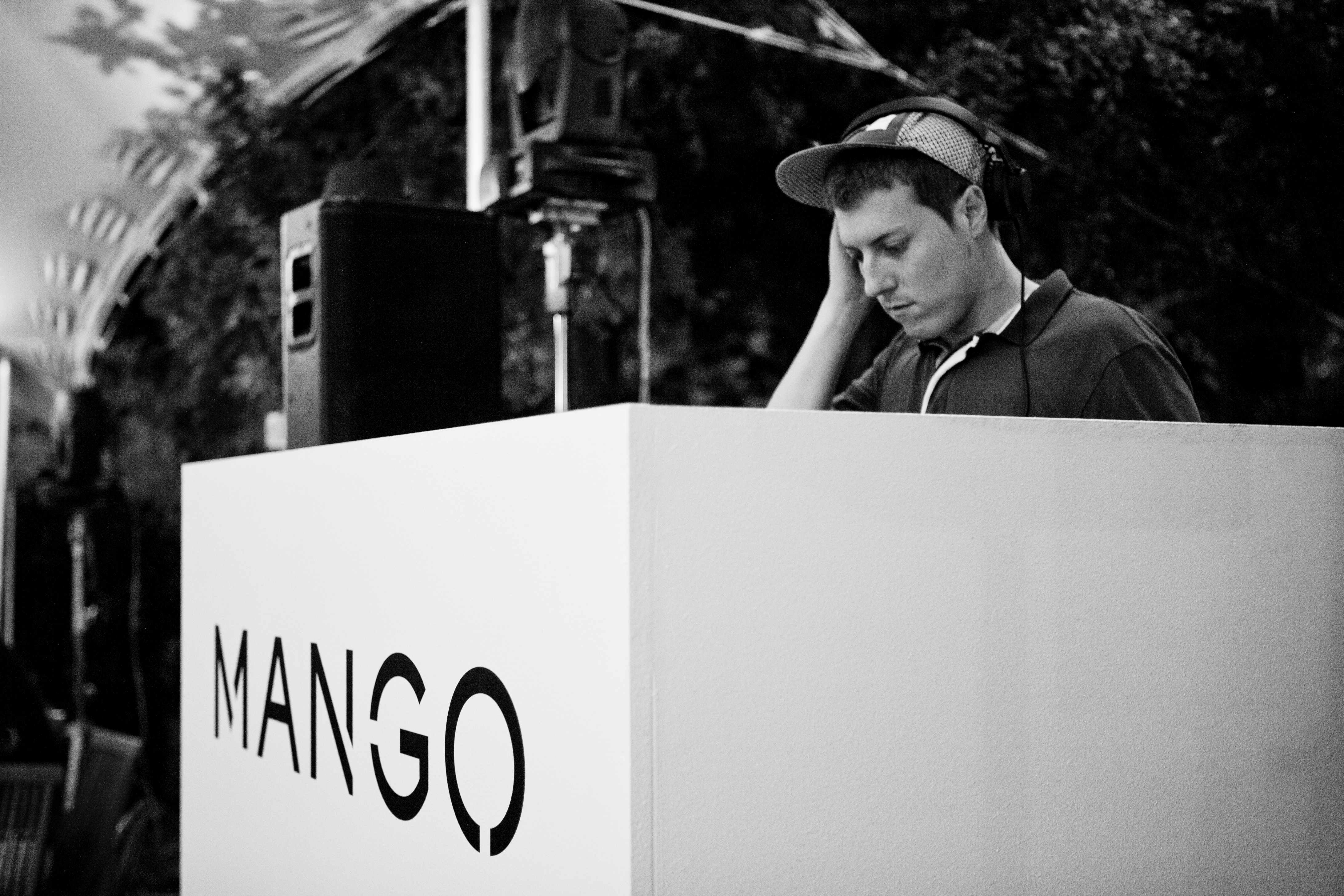 DJ con auriculares tras una cabina blanca con el logotipo de Mango, en blanco y negro, cocktail party de Mango producida por ESMA Events