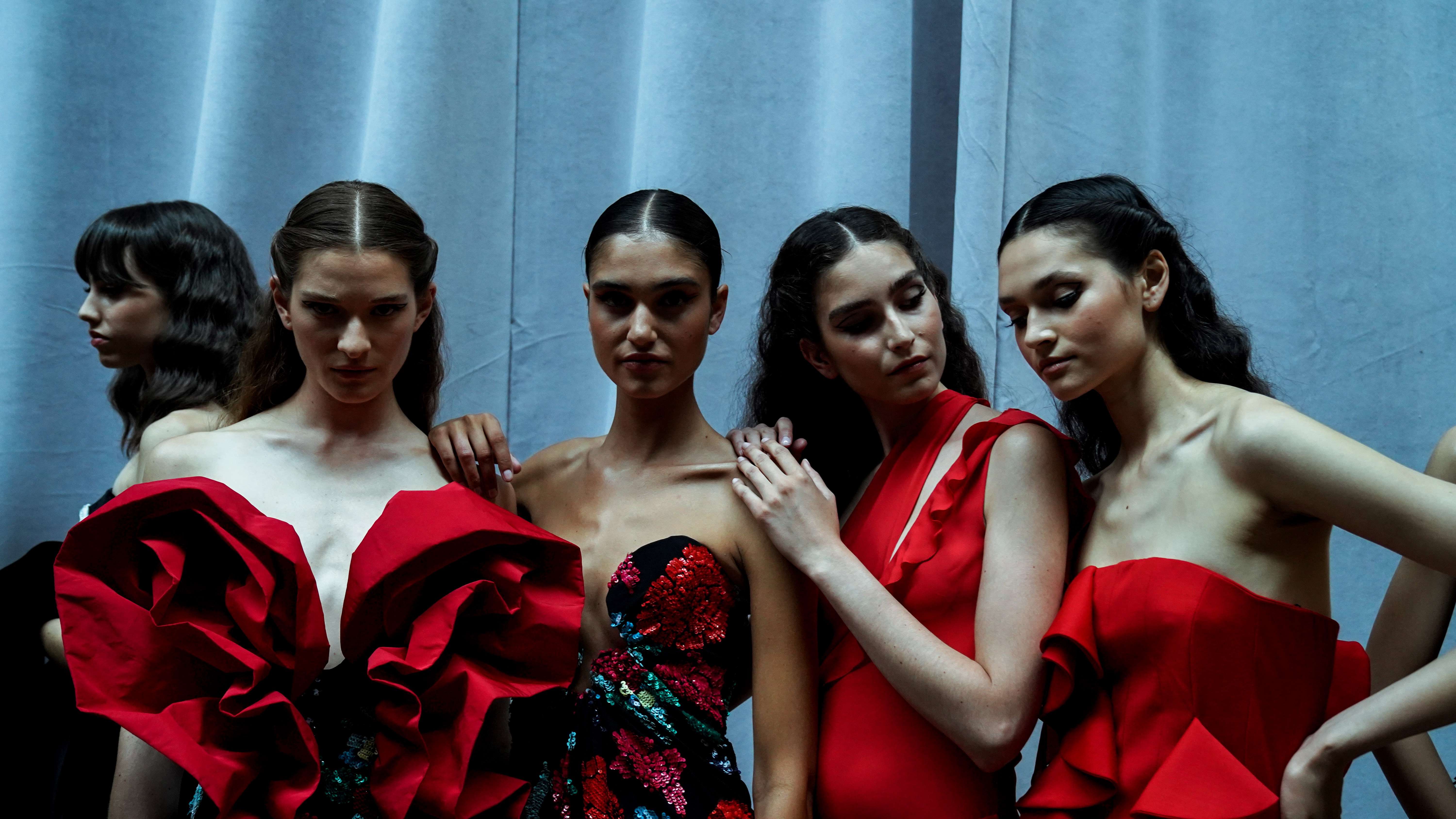 Group of models in red ruffled dresses posing backstage, Lola Flores Centenary exhibition by Redondo Brand produced by ESMA Events