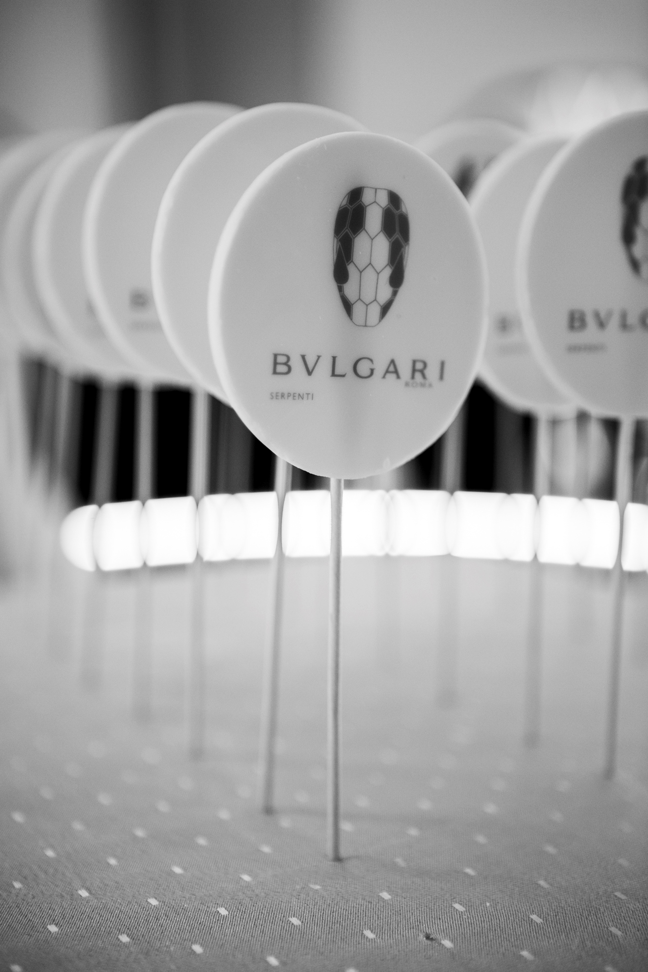 Piruletas blancas con el logotipo de Bvlgari sobre una mesa, en blanco y negro, inauguración de la boutique Bvlgari Serpenti de Barcelona producida por ESMA Events