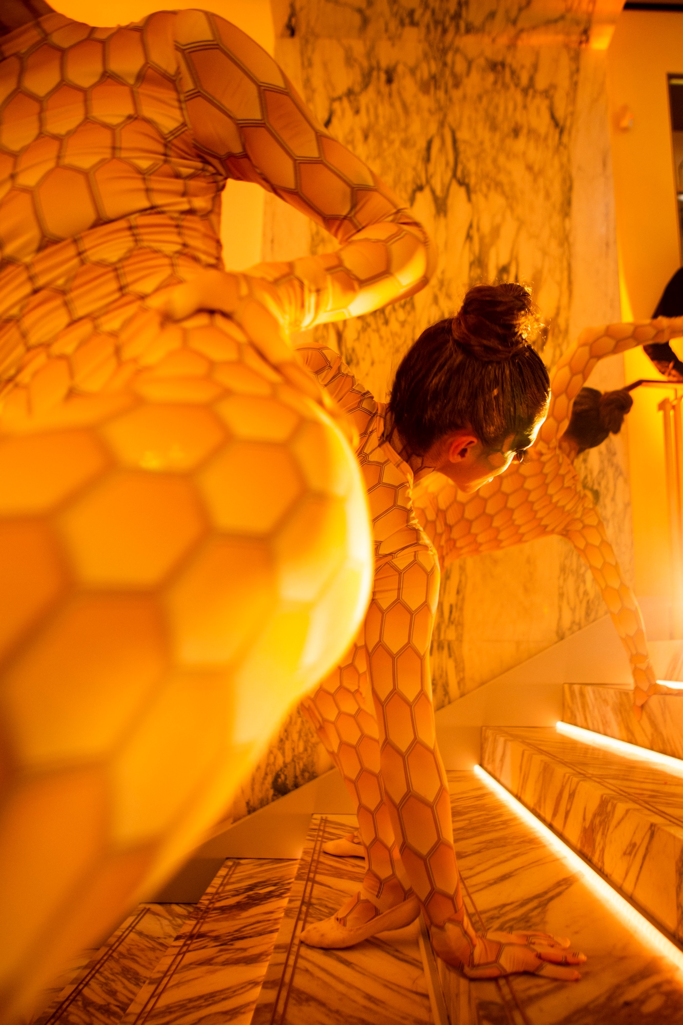 Dos intérpretes con cuerpos pintados de escamas doradas en una escalera iluminada, inauguración de la boutique Bvlgari Serpenti de Barcelona producida por ESMA Events