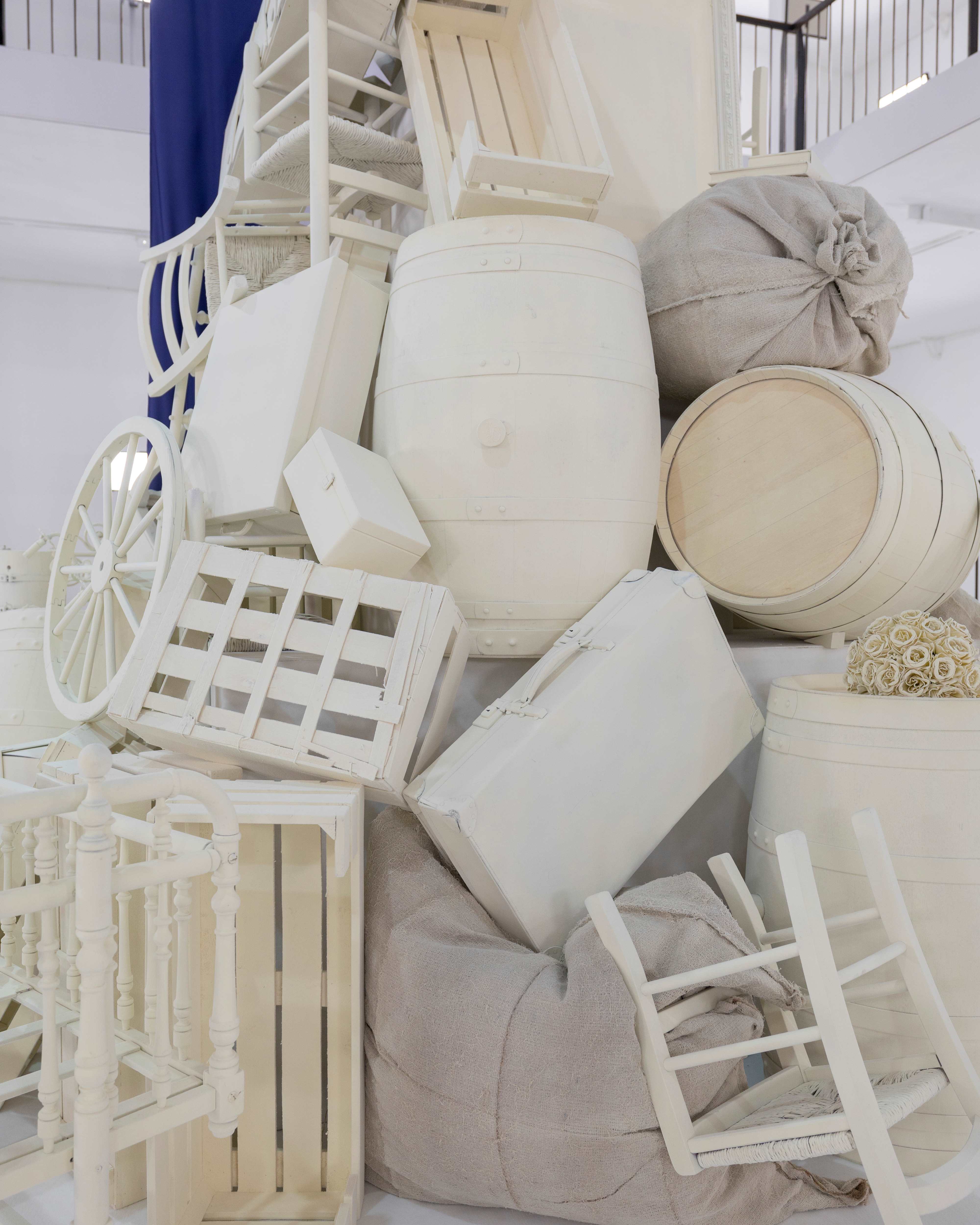 Detail of the installation with stacked white barrels, wooden crates and sacks, 1832 Sur Mer Teresa Helbig FW24/25 presentation produced by ESMA Events