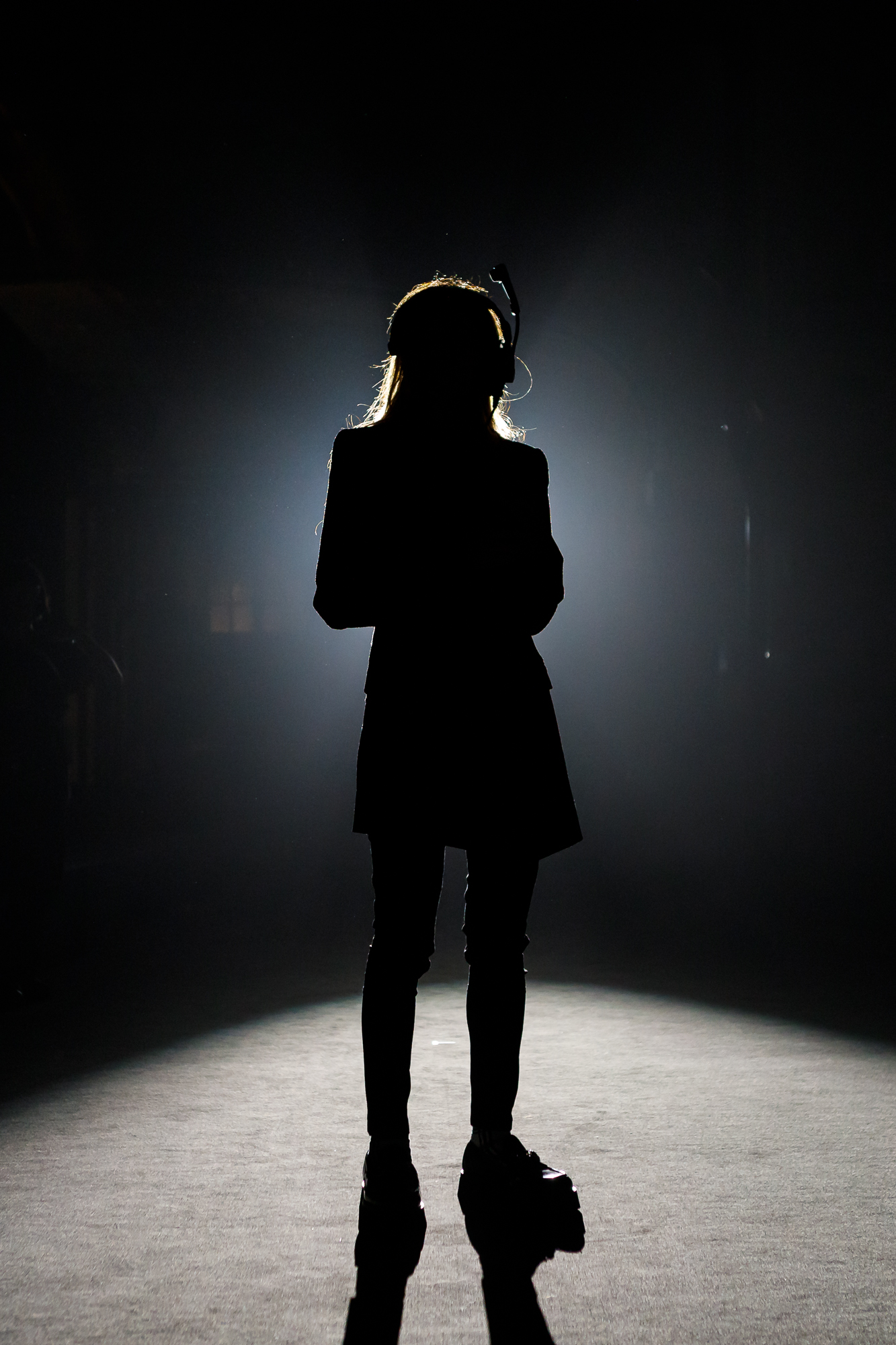 Silueta de una persona a contraluz sobre un fondo oscuro con halo de luz, 080 Barcelona Fashion FW 2024-2025 producida por ESMA Events