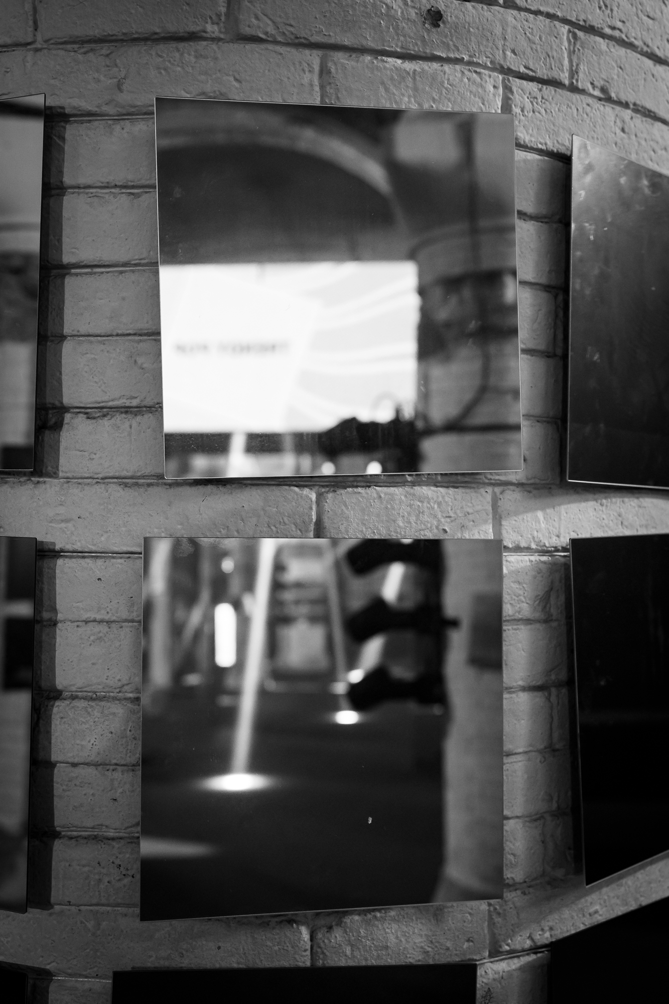 Pared de ladrillo con nichos y pantallas iluminadas, en blanco y negro, 080 Barcelona Fashion FW 2024-2025 producida por ESMA Events
