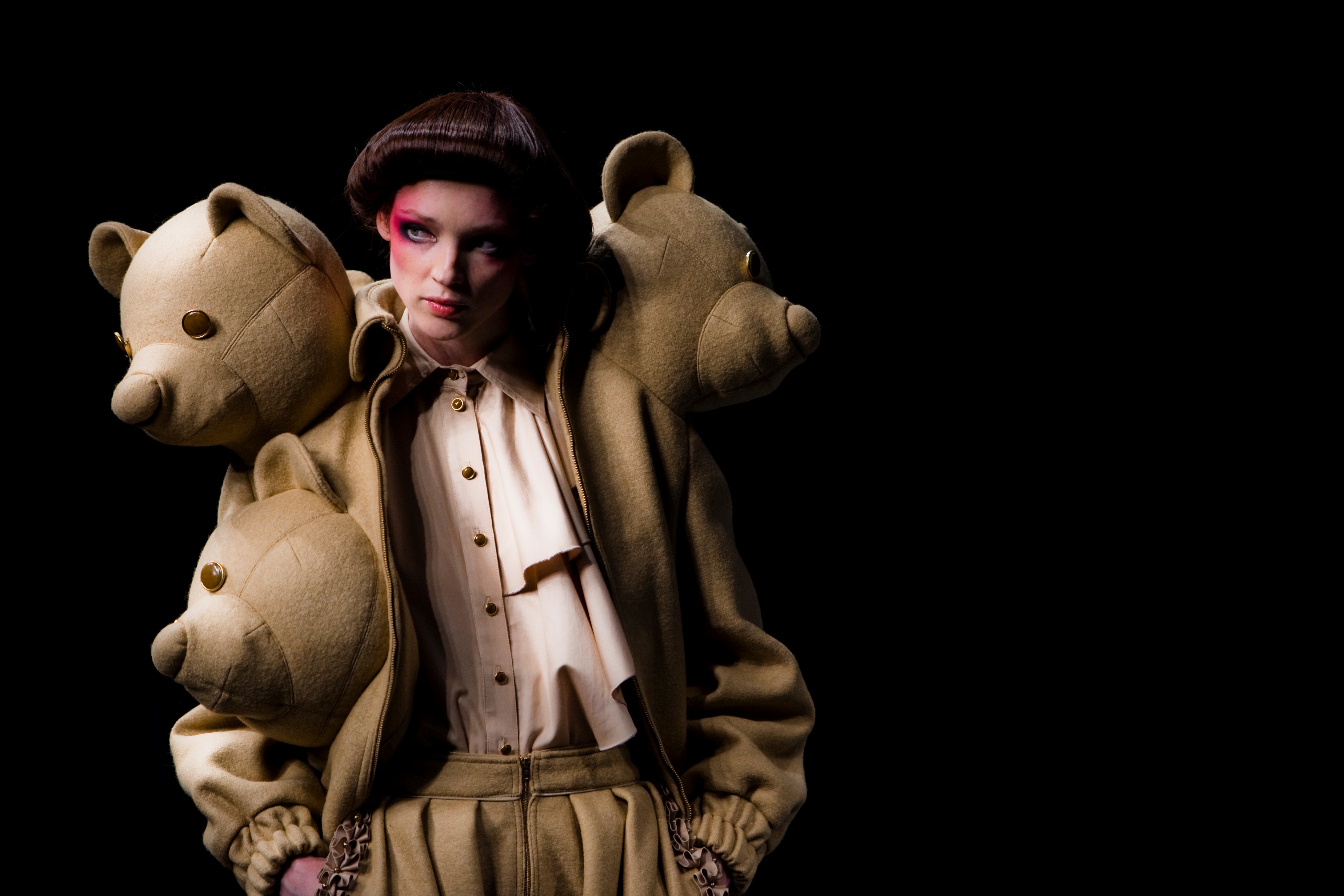 Retrato de una modelo con boina y maquillaje marcado junto a tres osos de peluche sobre los hombros, 080 Barcelona Fashion FW 2010-2011 producida por ESMA Events