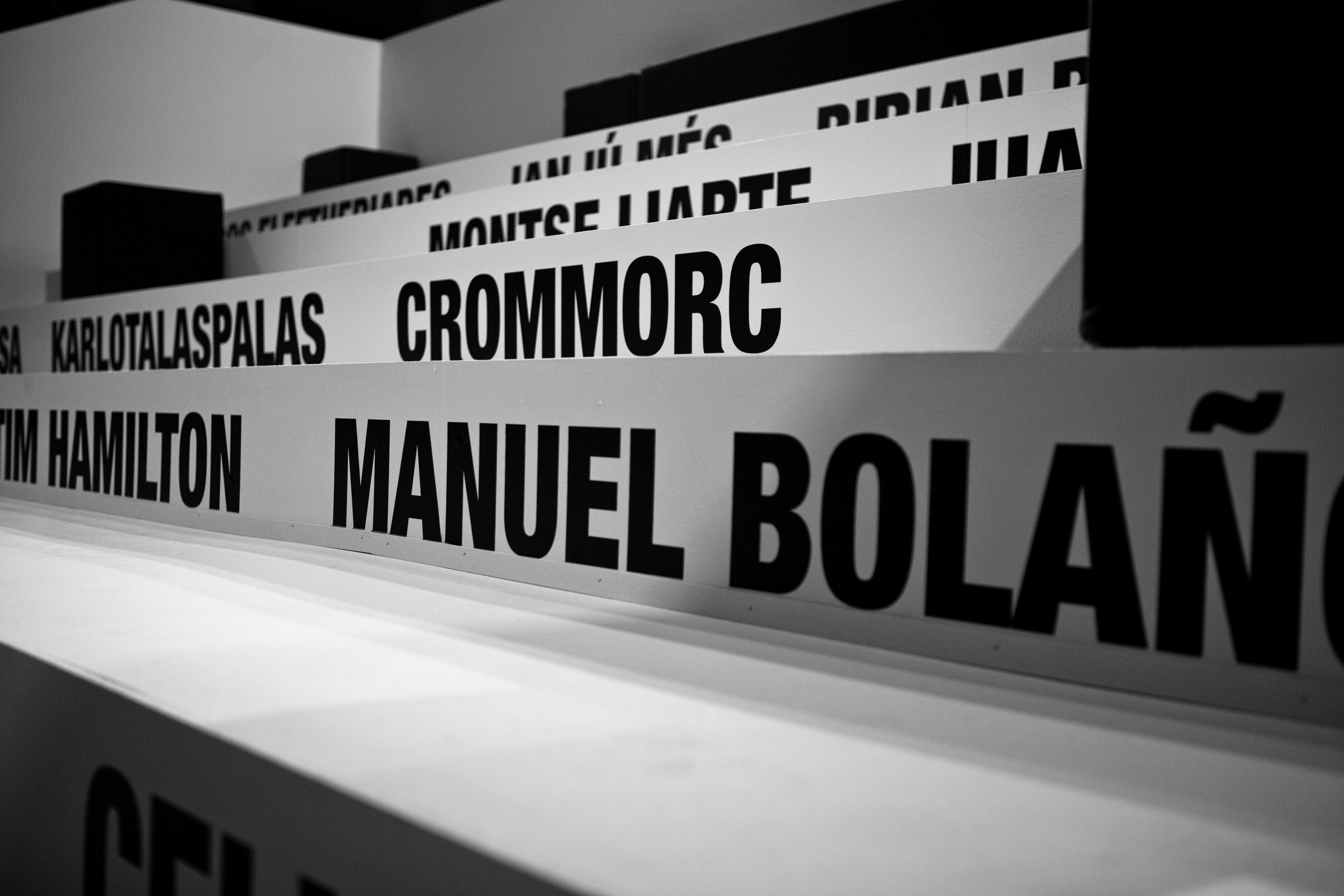 Rótulos negros con nombres de diseñadores sobre las gradas blancas, entre ellos Manuel Bolaño y Crommorc, 080 Barcelona Fashion FW 2010-2011 producida por ESMA Events