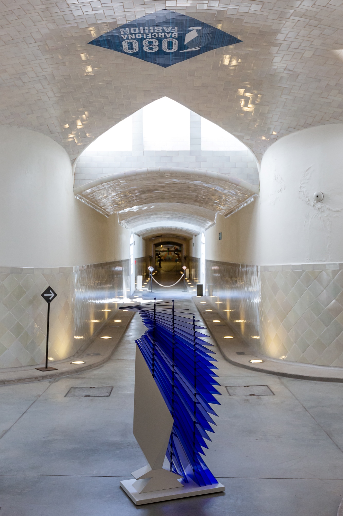 Escultura azul de lamas sobre un pedestal blanco en un vestíbulo abovedado con el logotipo 080 en el techo, 080 Barcelona Fashion FW 2019-2020 producida por ESMA Events