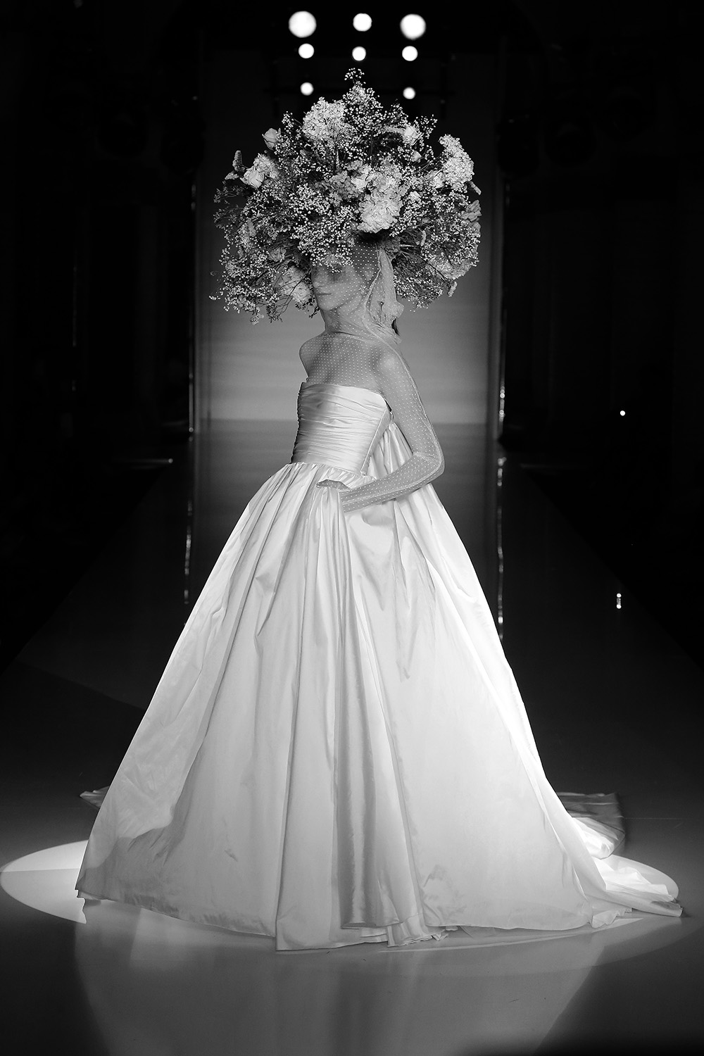 Modelo con vestido de novia blanco y un gran tocado de flores, en blanco y negro, 080 Barcelona Fashion FW 2019-2020 producida por ESMA Events