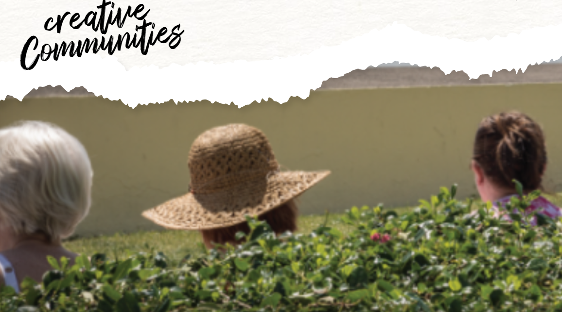 Title 'Creative communities' with 3 people's heads peaking out of a bush as they look ahead at a mountain view. 