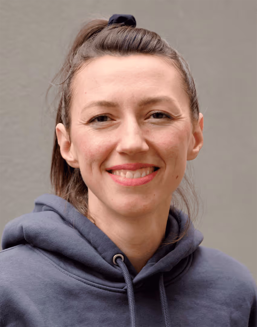Porträt von Maria Dax, Customer Success Managerin bei kaayo, vor grauer Betonwand, professionell.