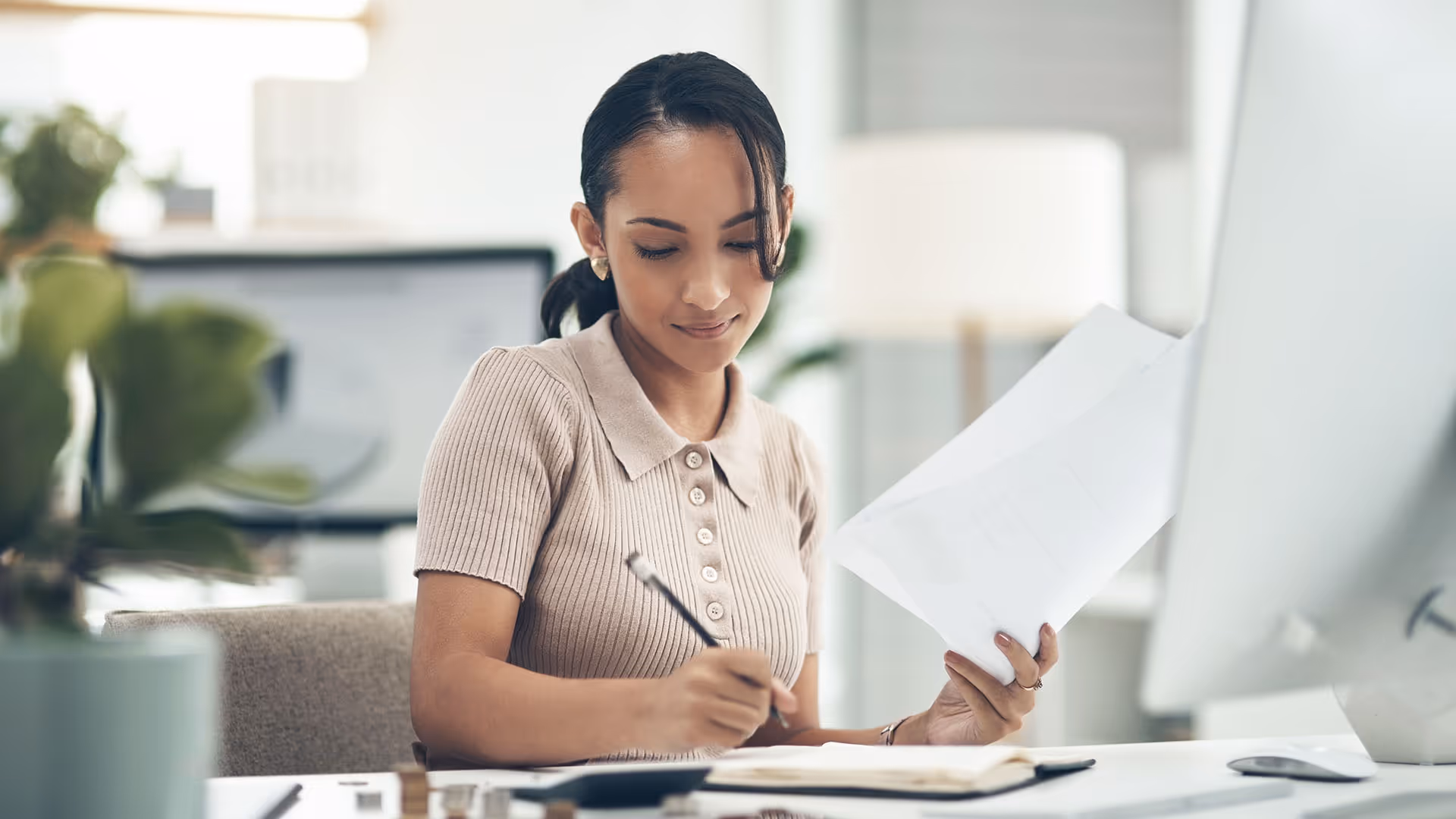 Woman fills sets up employee payroll at her desk.