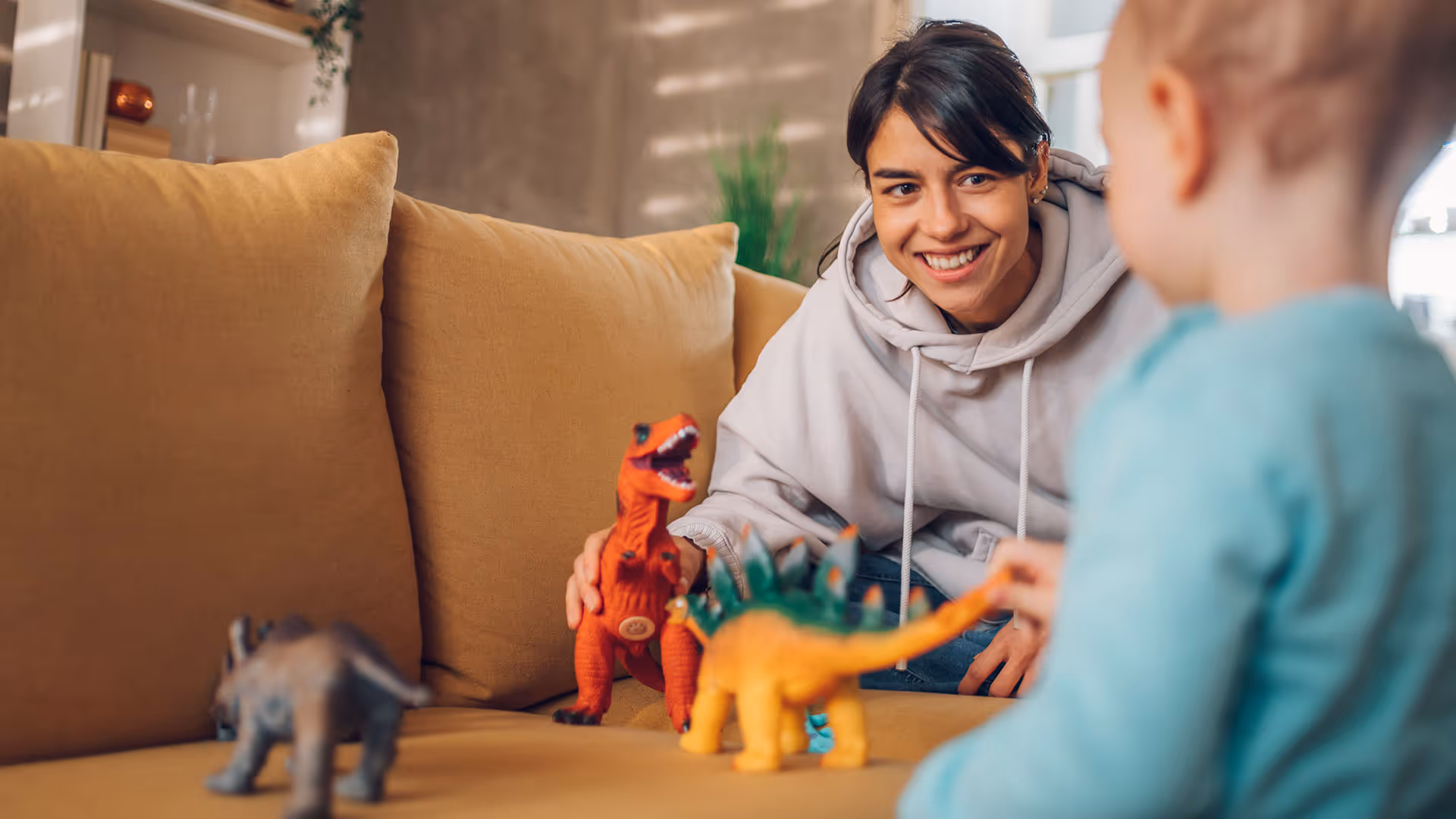 Nanny plays with child on couch