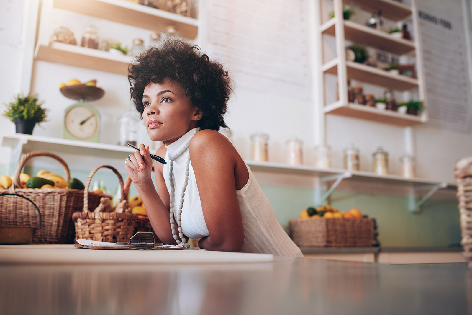 Small business owner in her store thinking about hiring some help