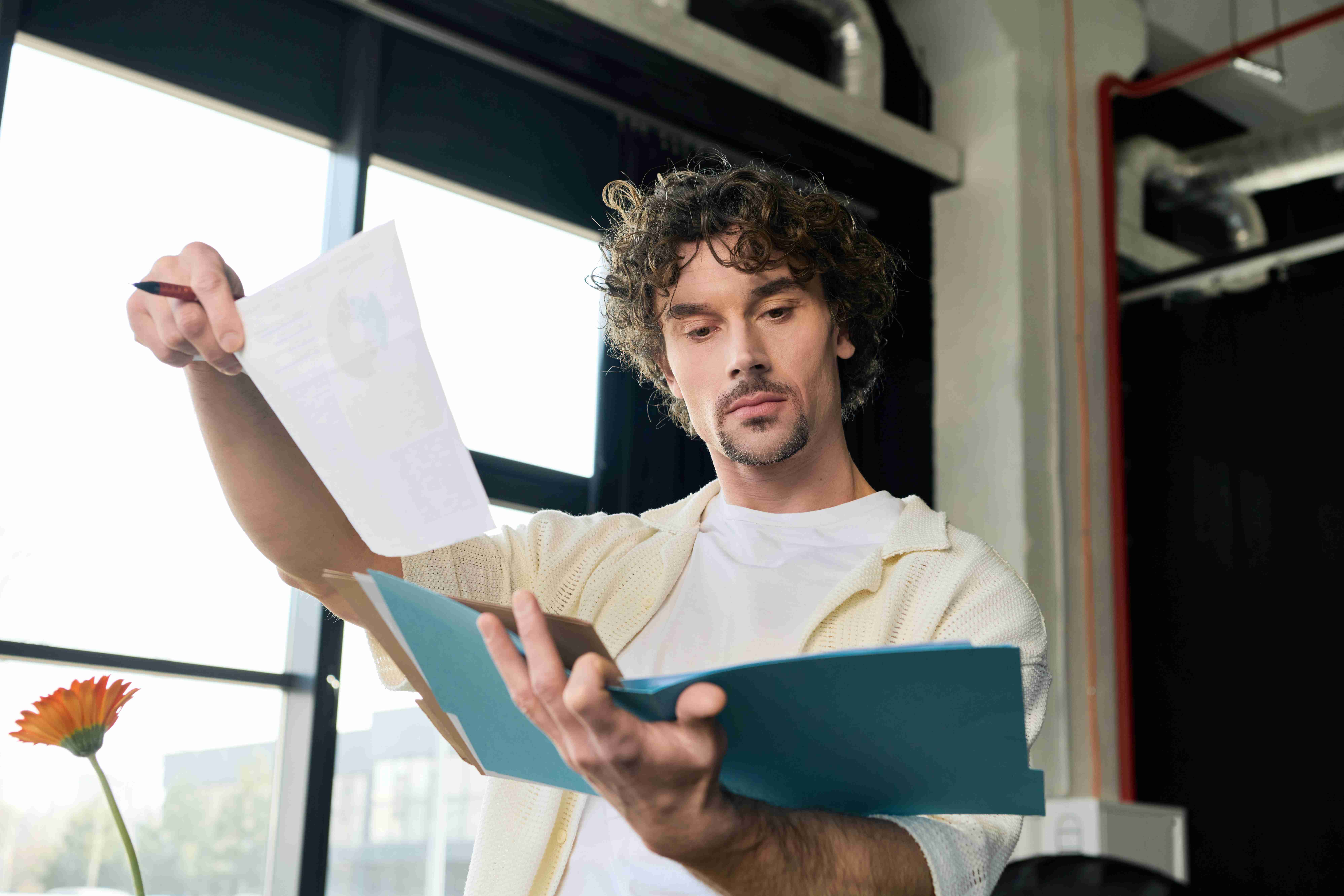 Male business owner reviewing documents in office.