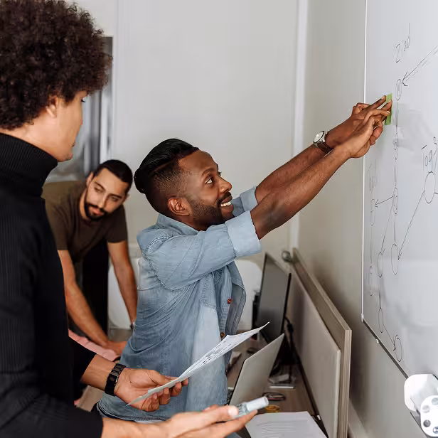 A startup founder draws a business plan on the whiteboard.