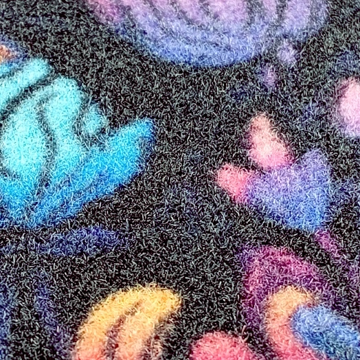 Motif coloré de feuilles stylisées sur un fond noir texturé.