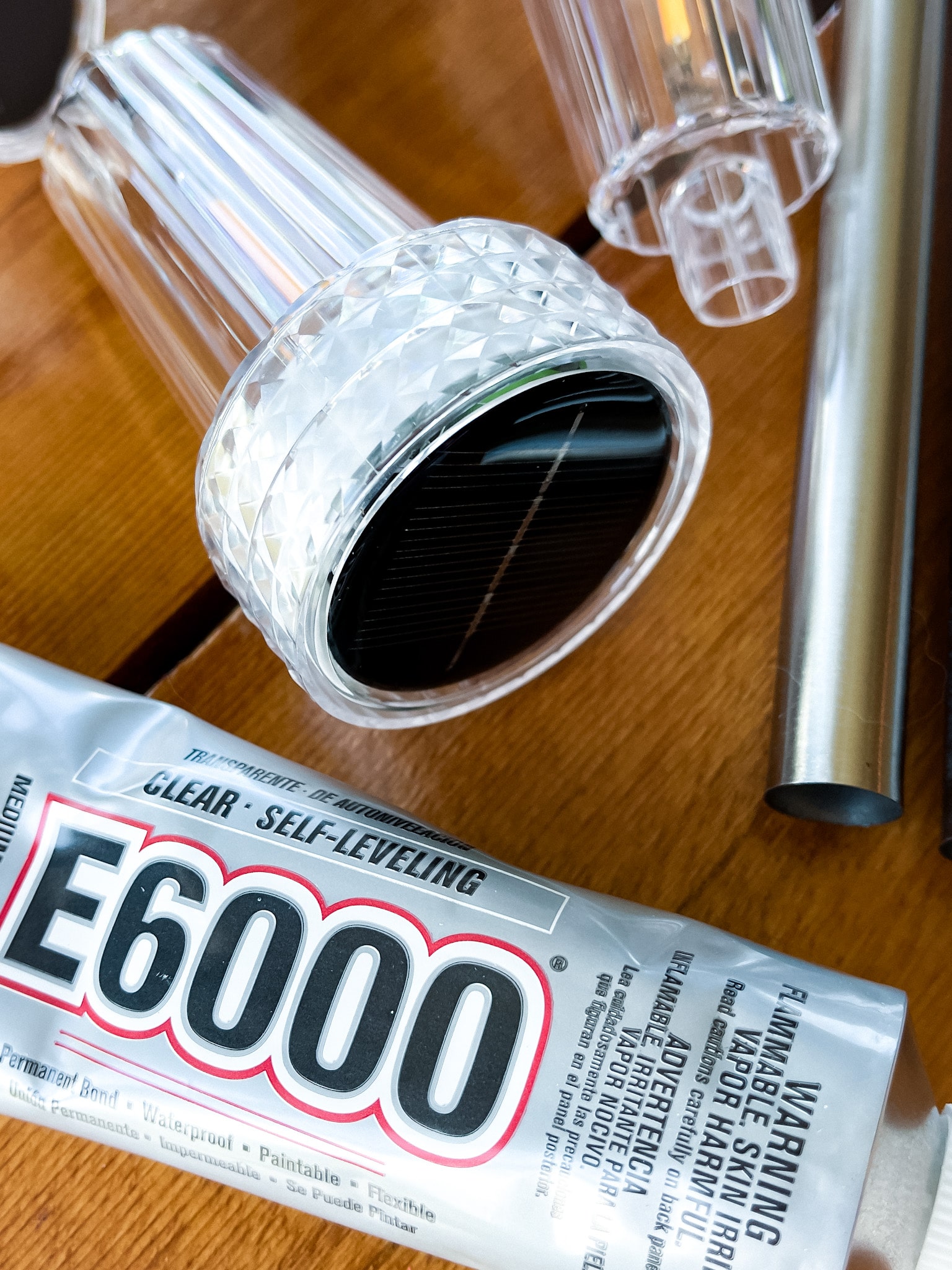 on a table: solar lights, e6000, and plastic bowls 