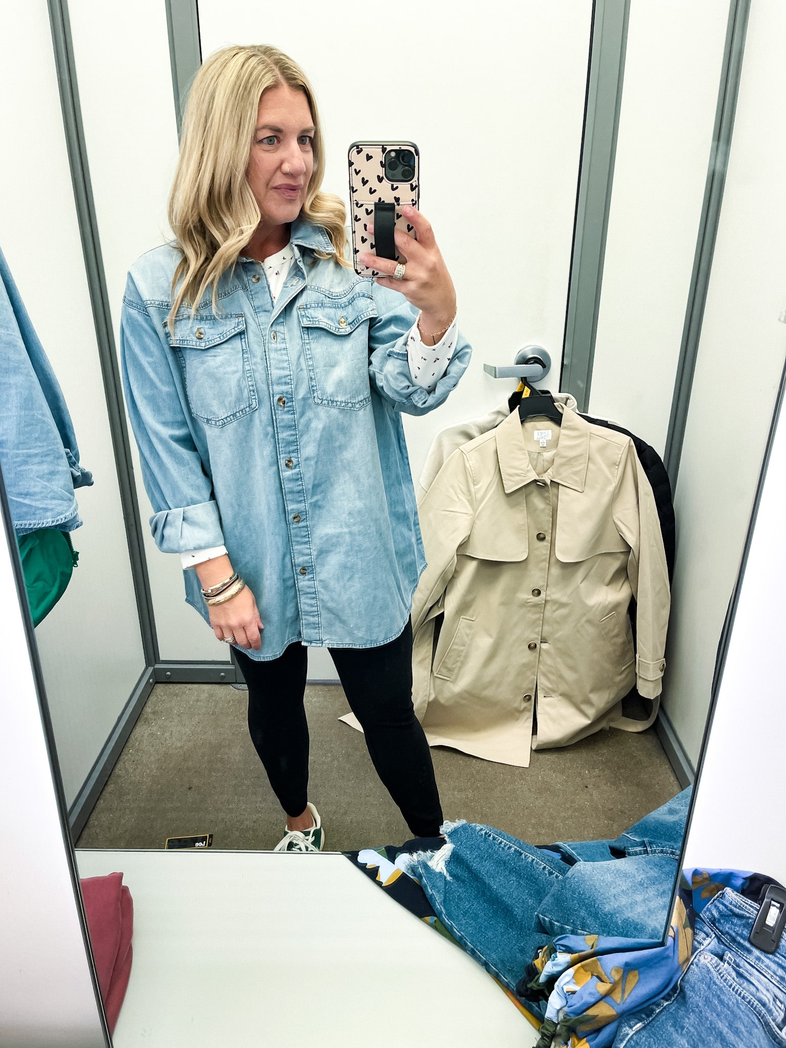 midsize woman trying on clothes at walmart - denim shirt and black leggings
