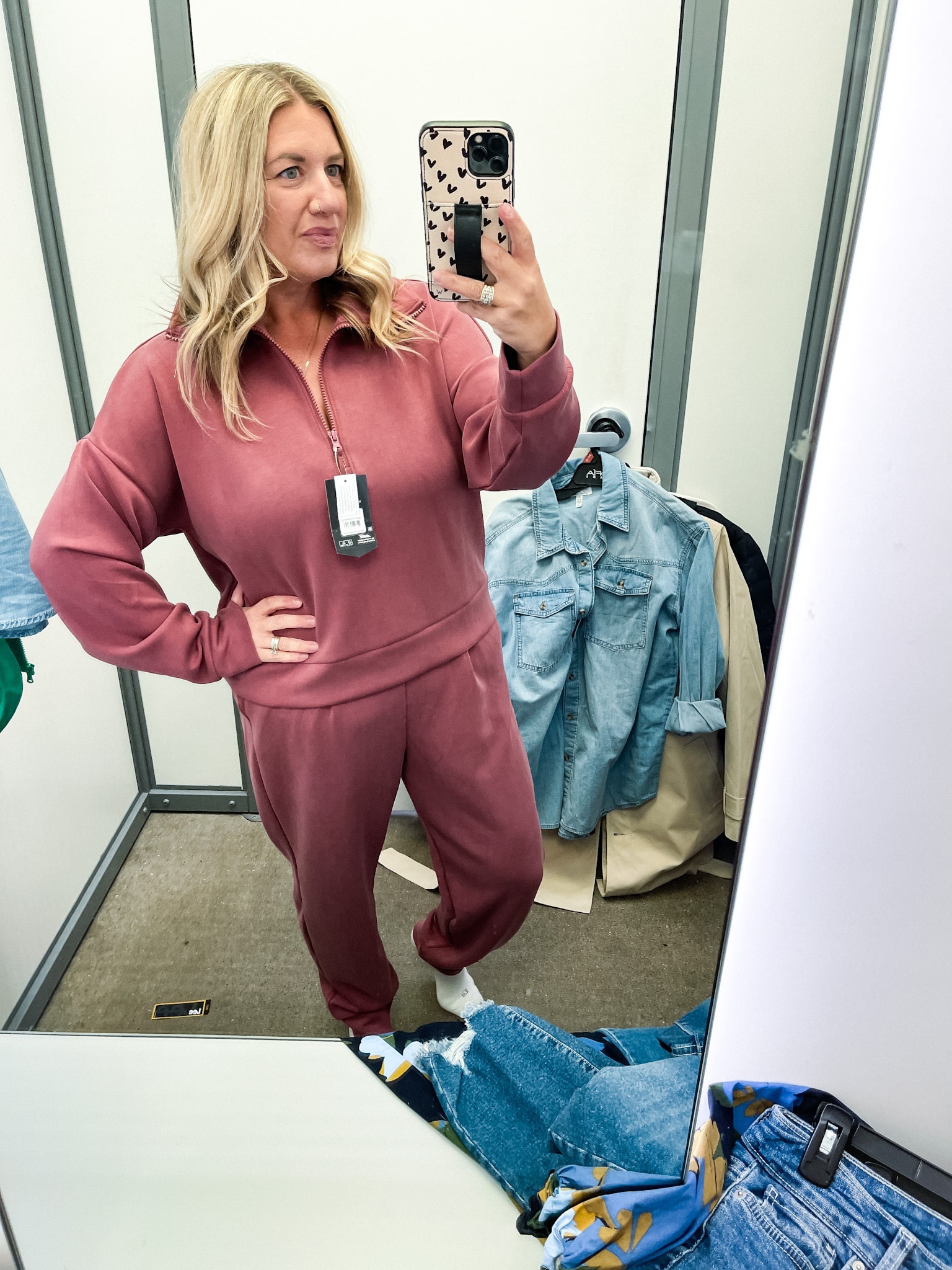 midsize woman trying on clothes at walmart - rose colored joggers and half-zip sweatshirt