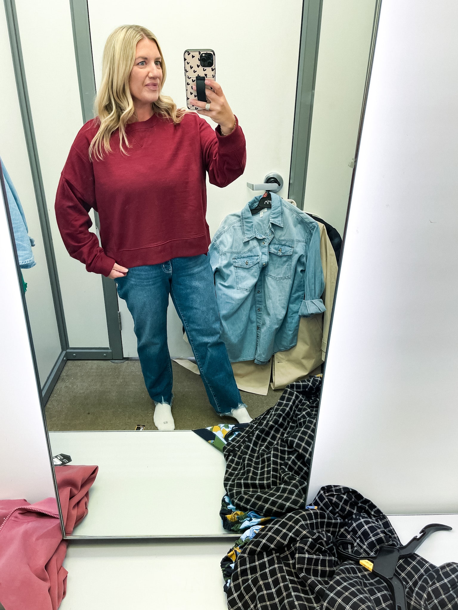 midsize woman trying on clothes at walmart - cropped crew neck sweatshirt and raw hem jeans