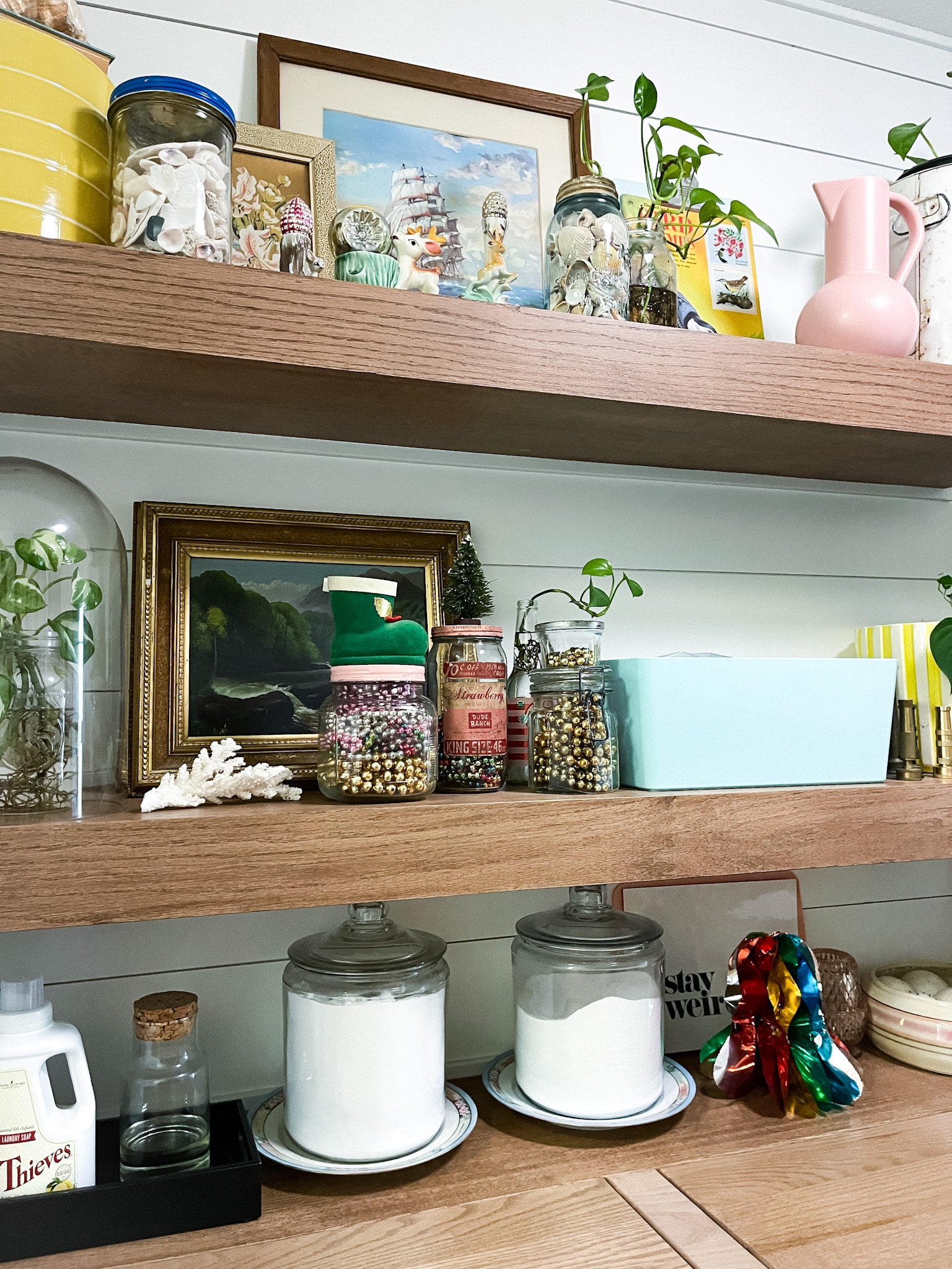 Floating shelves decorated with vintage decor in yellow and pink. Vintage mercury glass garlands styled on the shelves in jars.