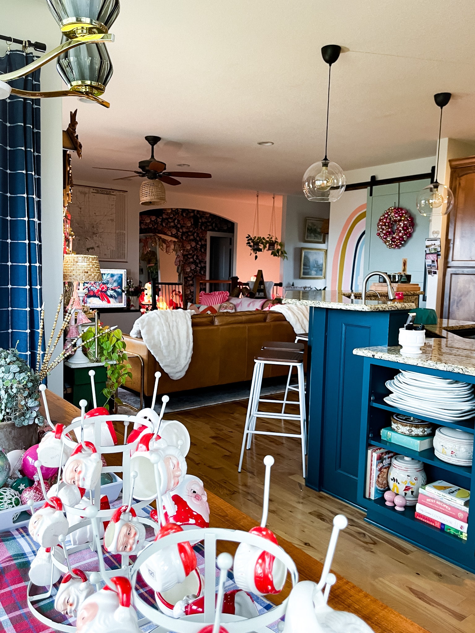 view of an open concept home's main level. blue painted island, leather sofa, lots of vintage decorations all aroundl