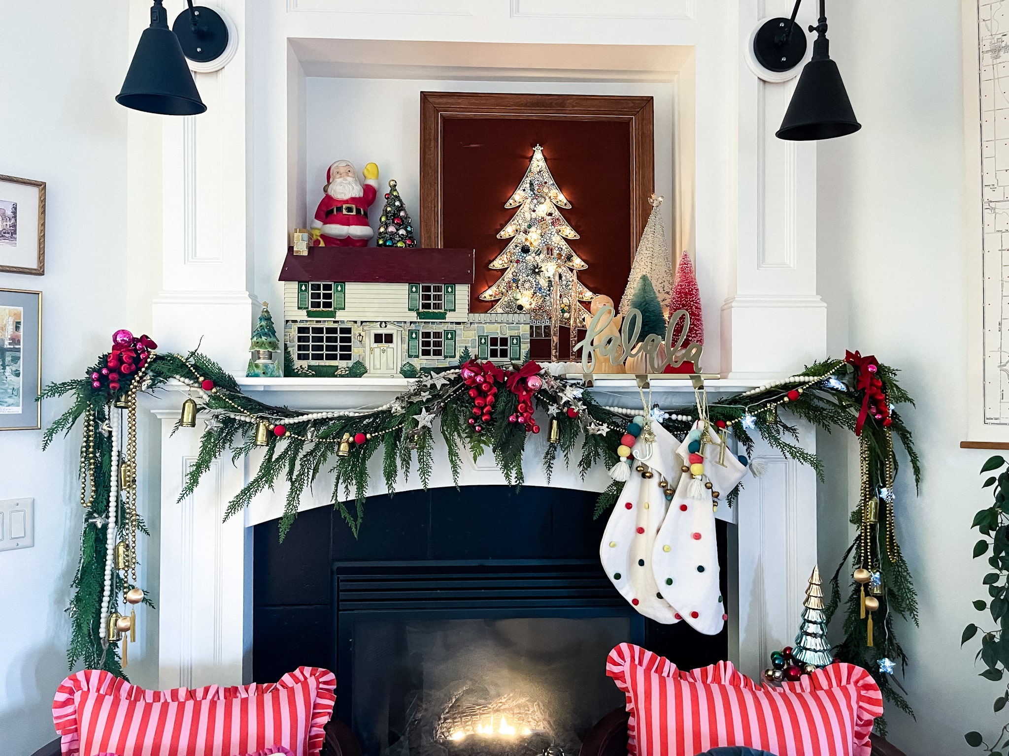 fireplace and mantel decorated for christmas, two accent chairs in front with pillos, and an art tv