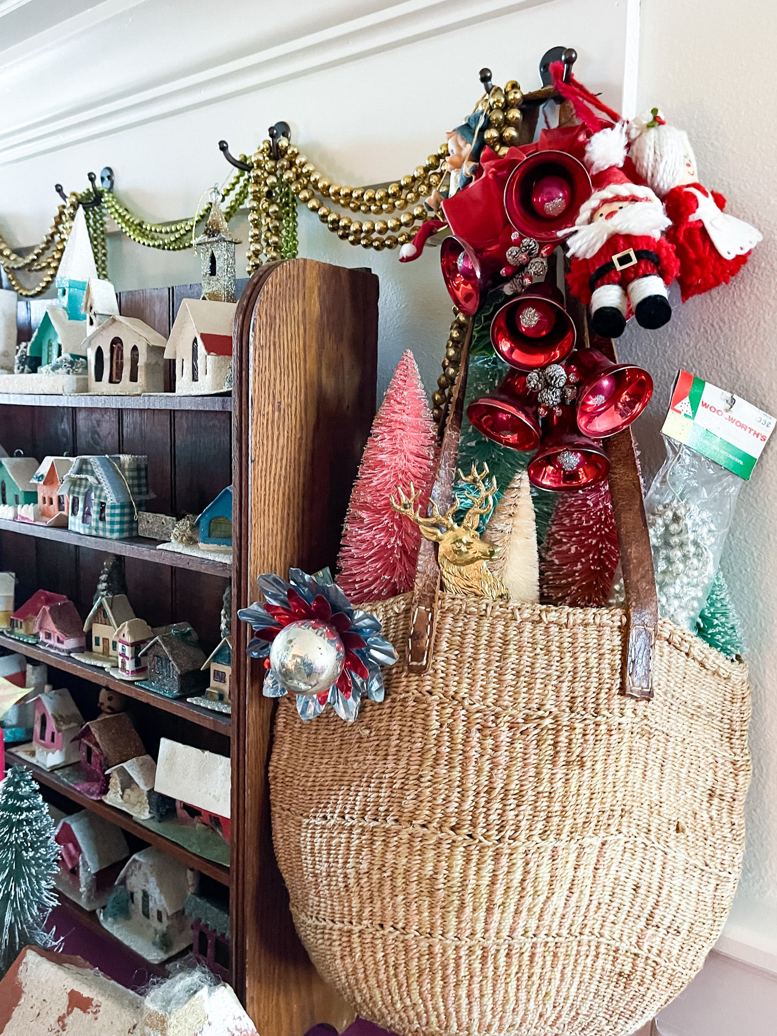 fuchsia commode decorated with vintage christmas decor, including putz houses, mercury glass garland, and plants