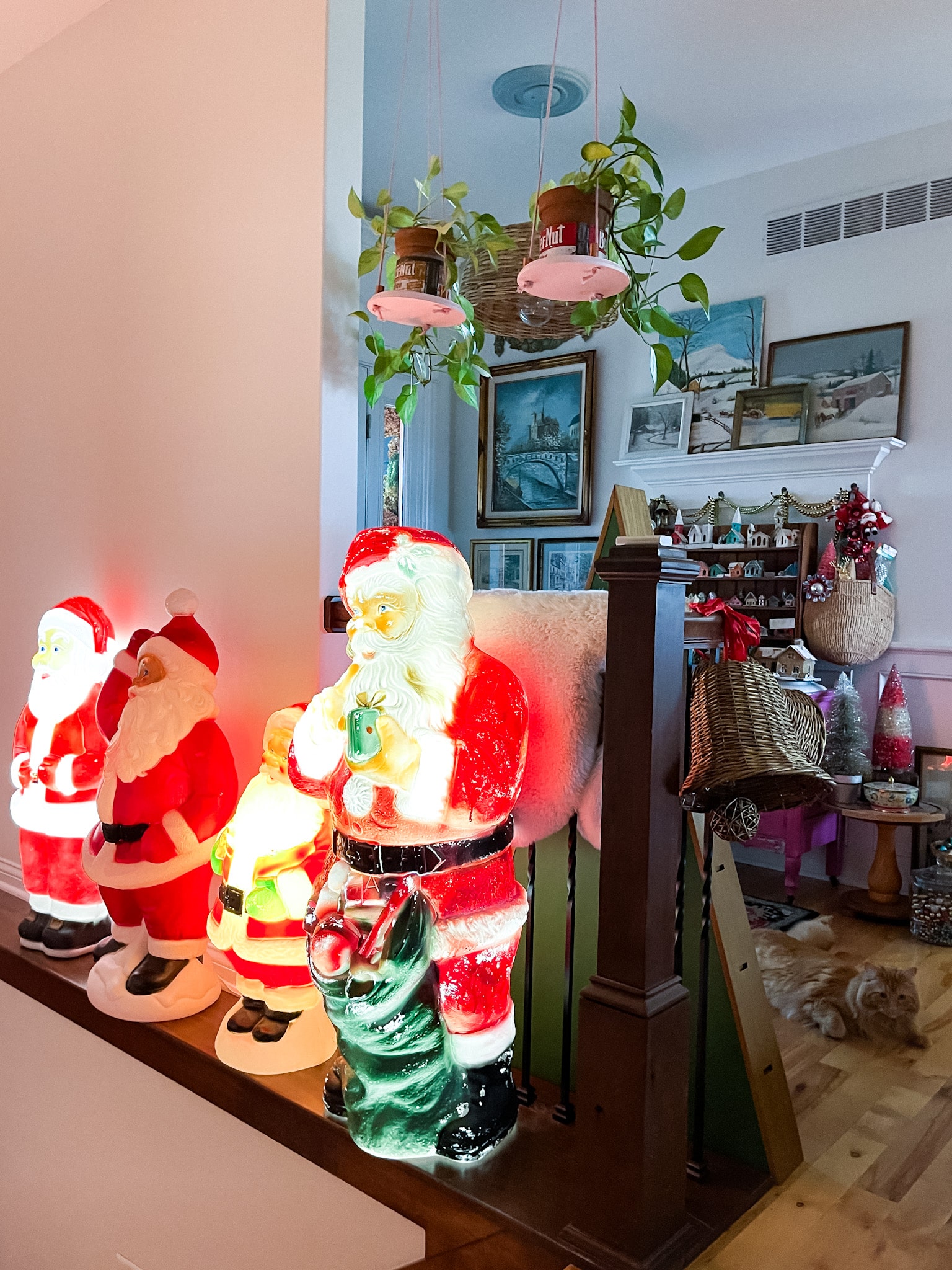 vintage santa blow molds lined up along a ledge in a stairway