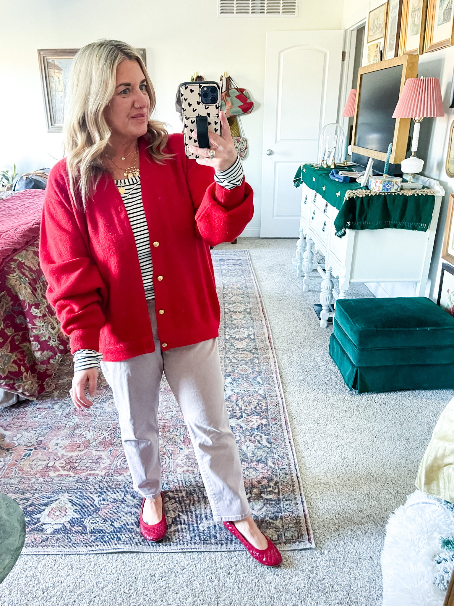 woman in a red sweater, black and white striped shirt, pink pants, and red shoes